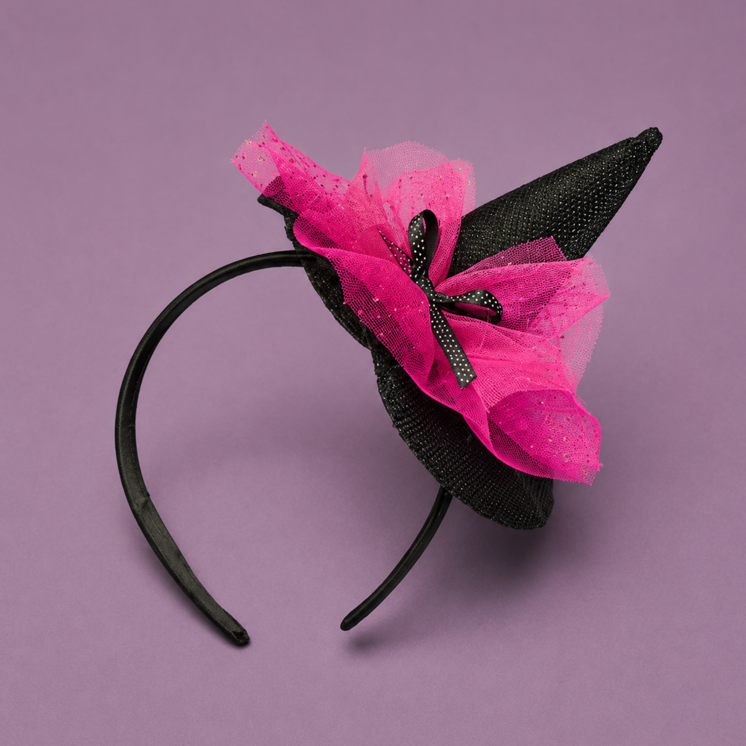 A black headband with a pink tulle detail and a witches hat. 