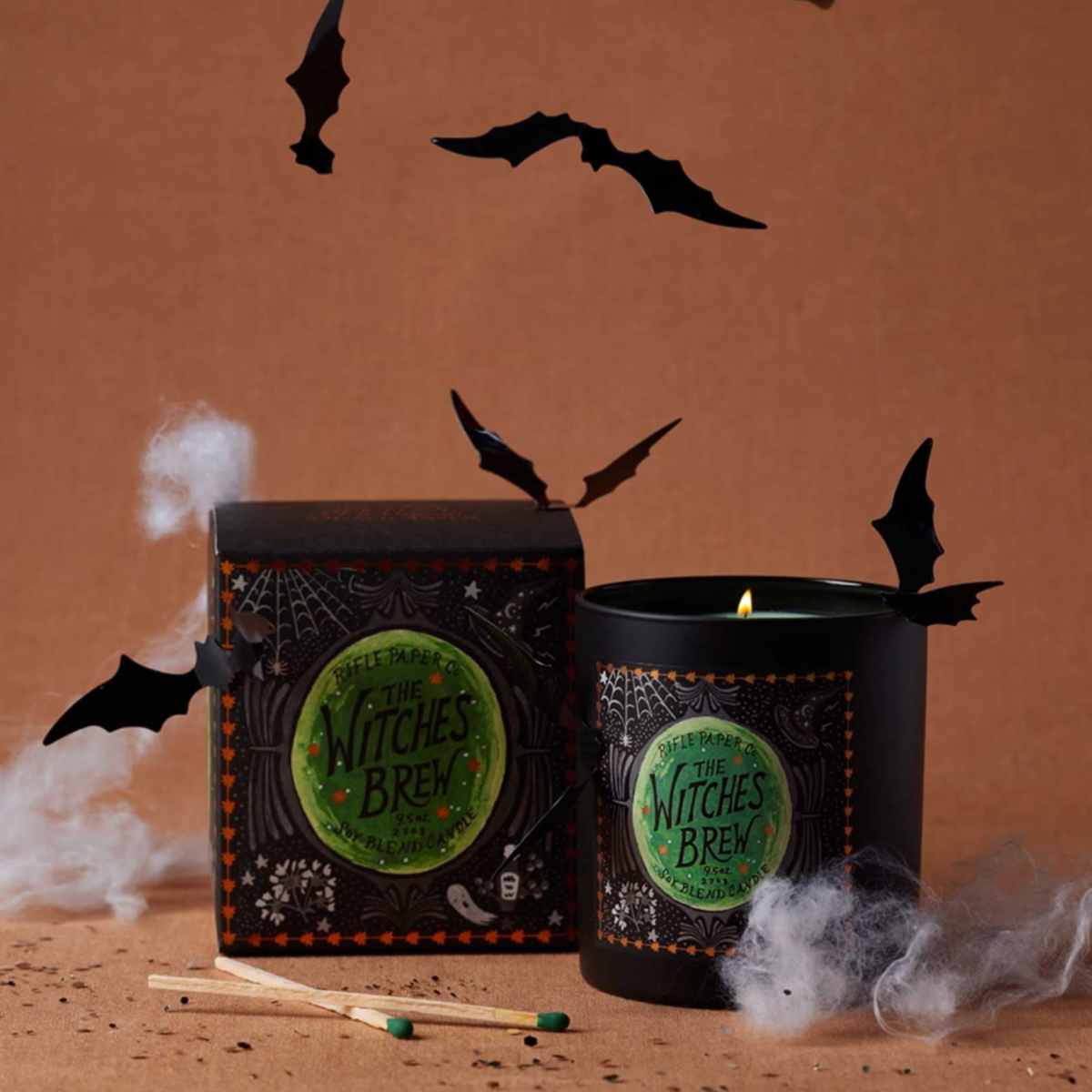 A black jar candle with a green label that reads, "The Witches Brew". 