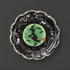 A black and silver paper plate with a witch design in the center. 