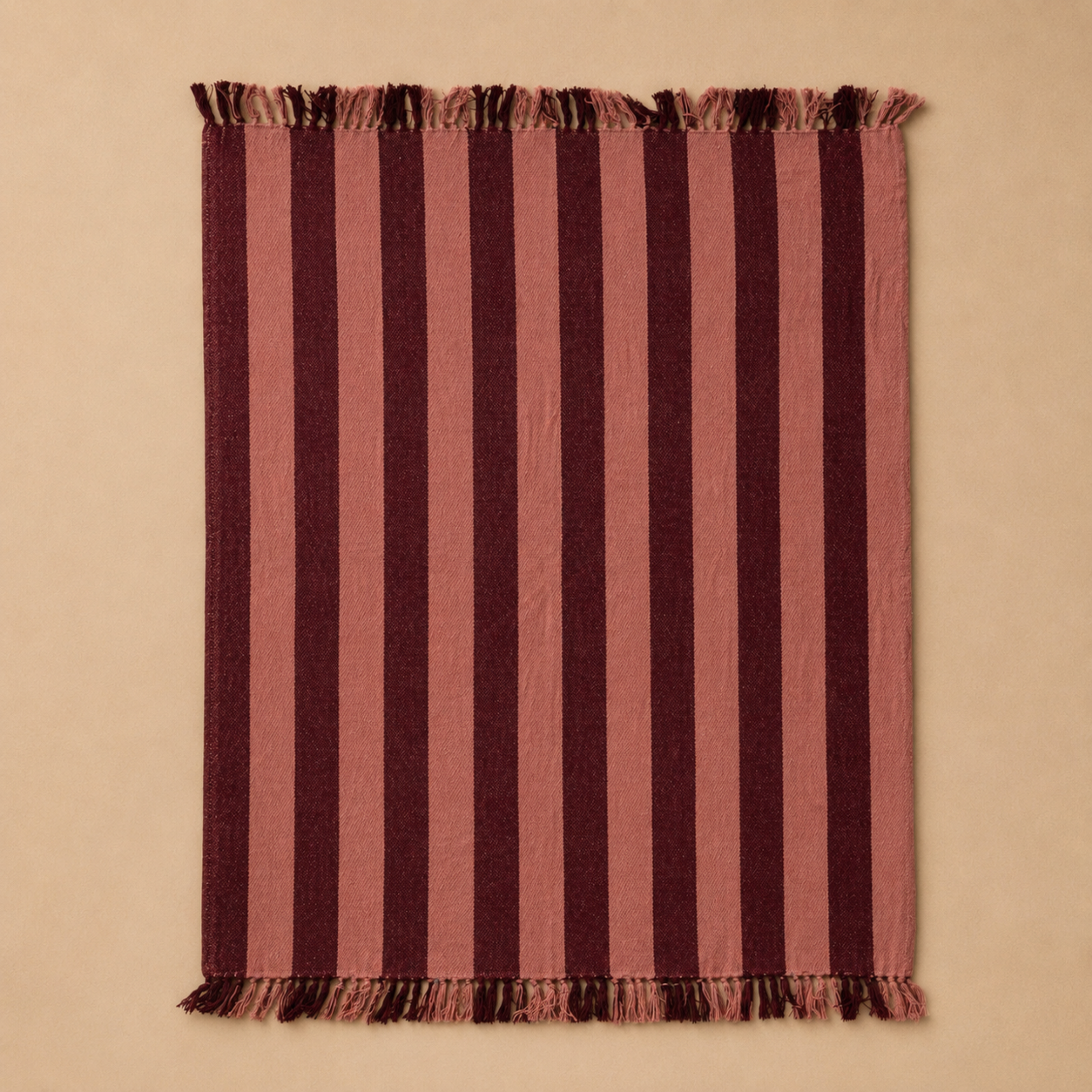 a pink and burgundy woven throw blanket.