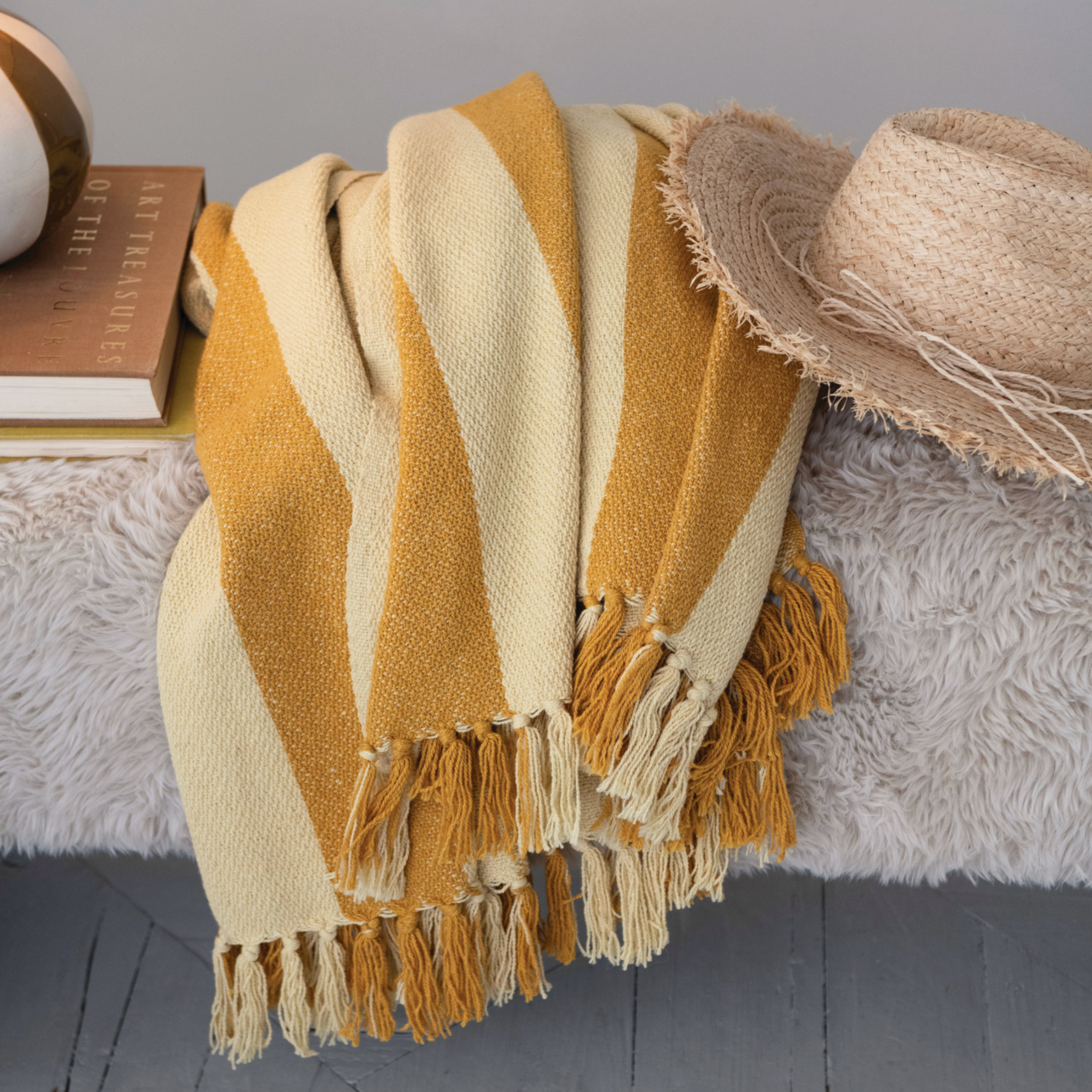 a yellow and tan woven striped throw blanket