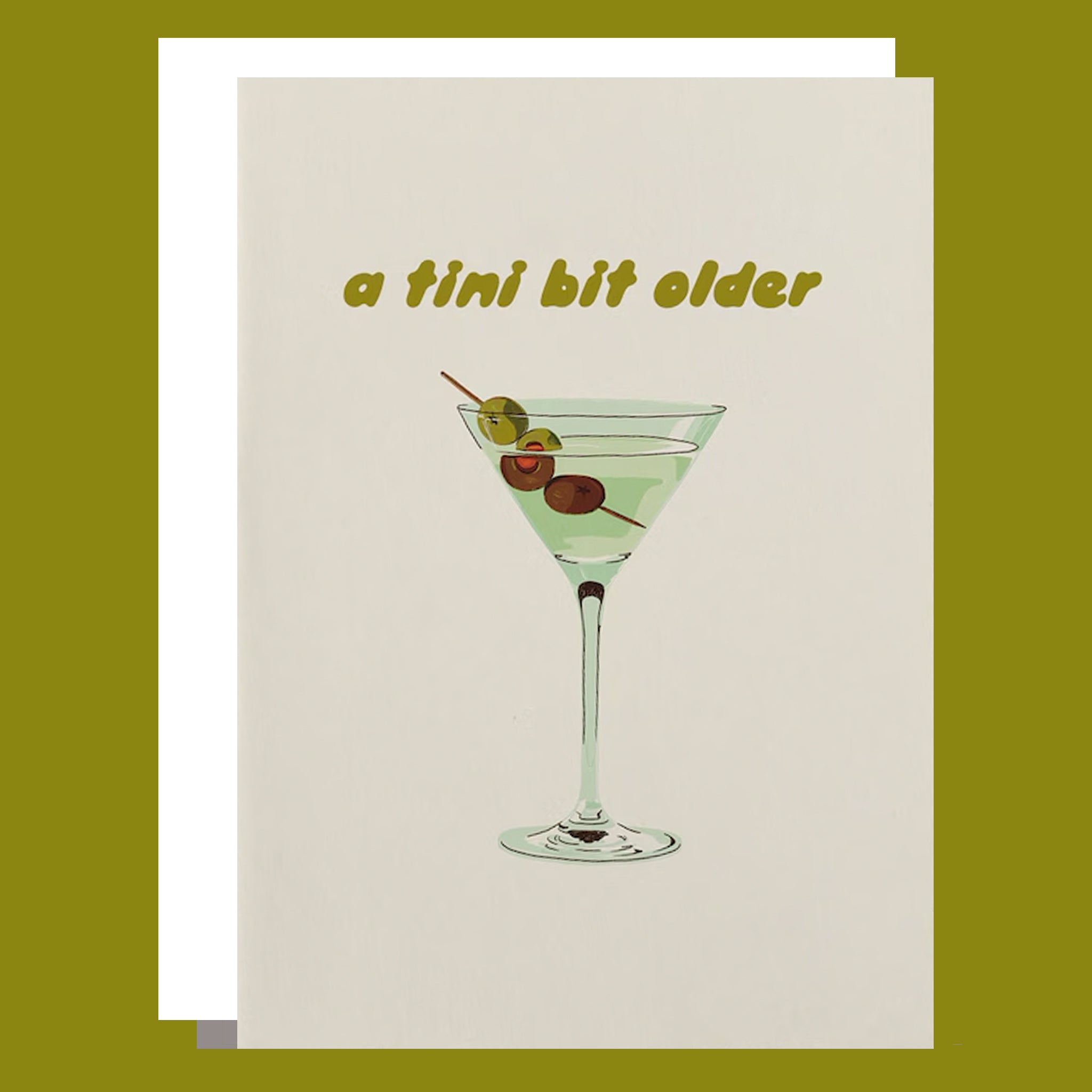 a white card with a martini graphic on the front and text above that reads, &quot;a tini bit older&quot;. 