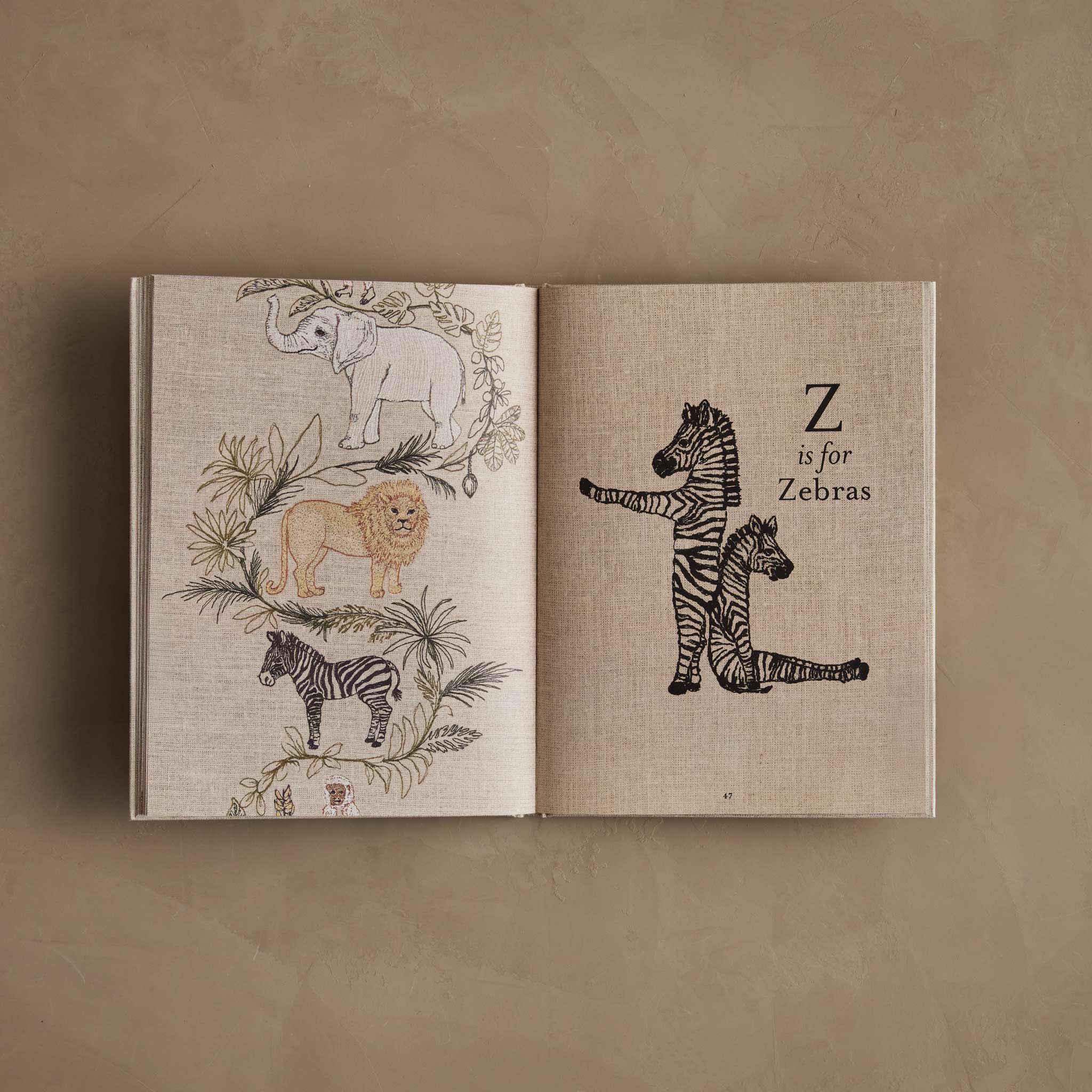 Open children’s alphabet book spread with illustrated animals; the right page reads ‘Z is for Zebras’ next to drawings of two zebras.