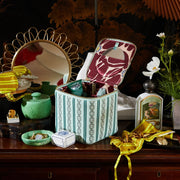 Green makeup pouch with a gold zipper shown on a vanity.