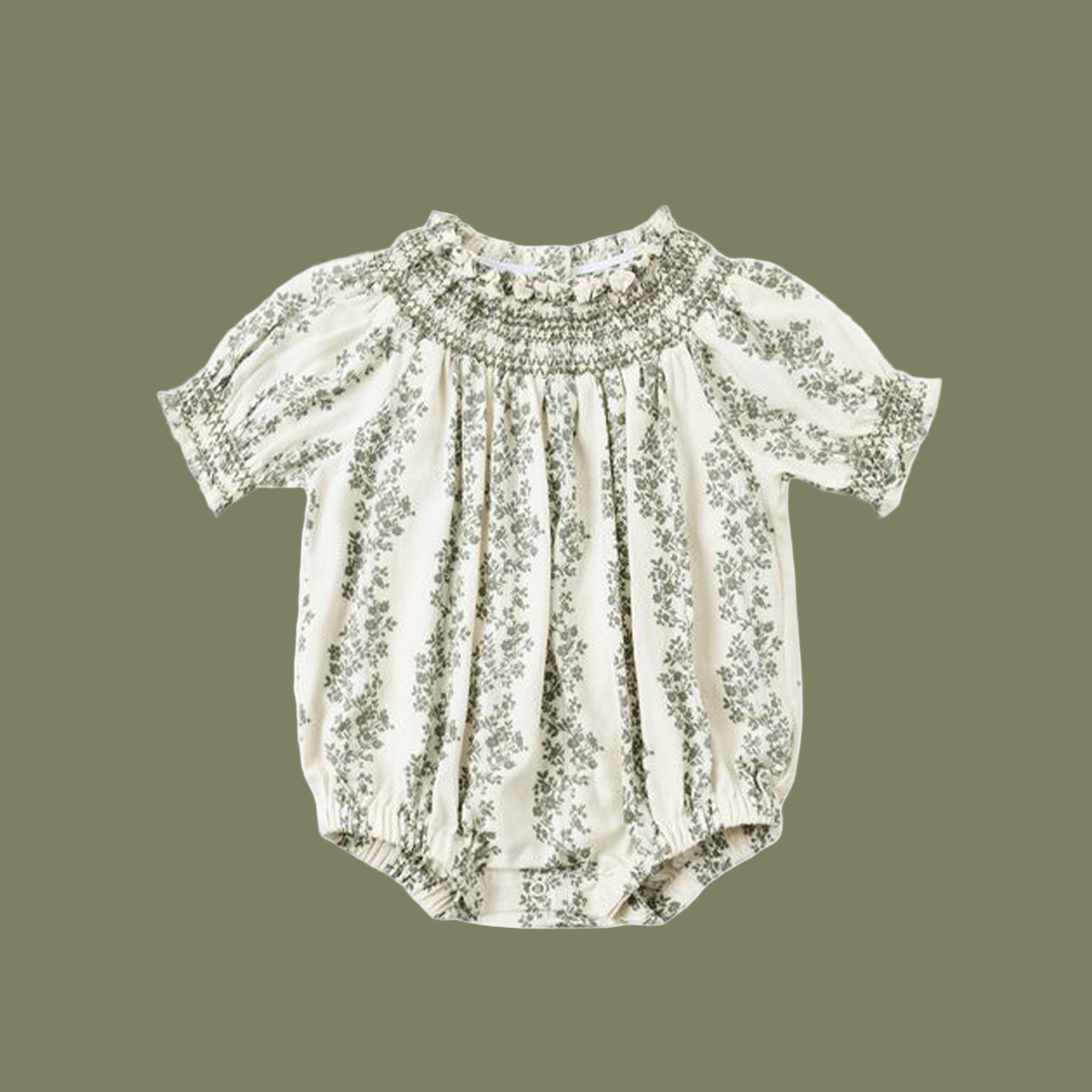An ivory romper with green vine details. 