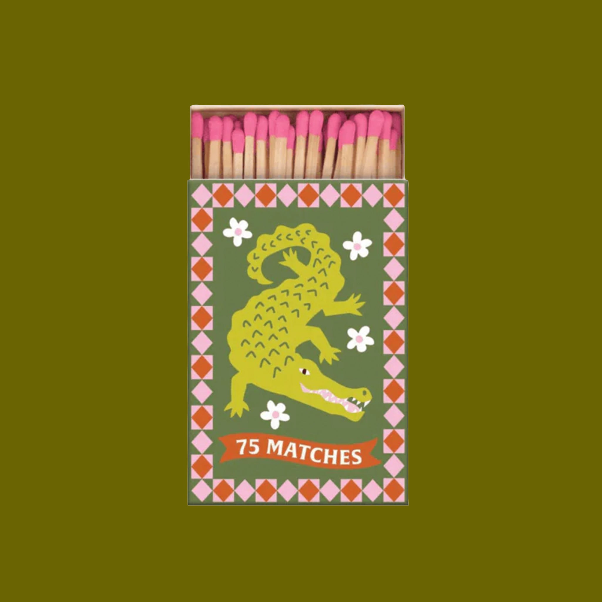 A box of pink tipped matches with a crocodile motif and flowers printed on the box.