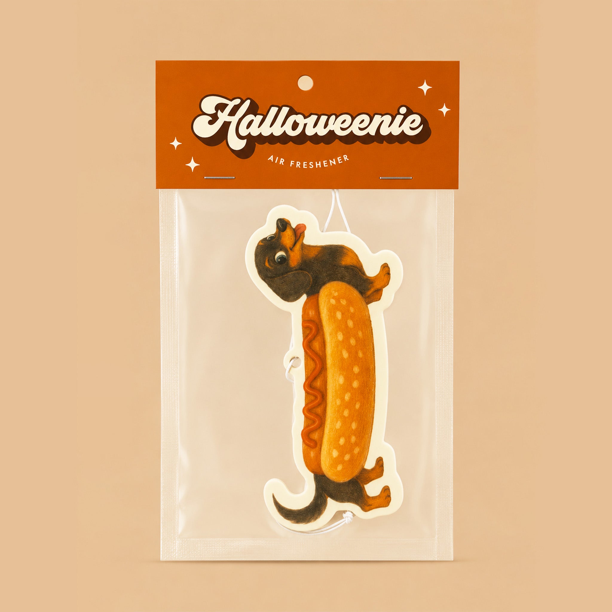 A packaged Halloween air freshener shaped like a dachshund dressed as a hot dog, shown in a clear plastic bag with an orange header card that reads 'Halloweenie Air Freshener.'.