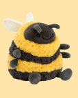 A brownish black and yellow bee shaped stuffed animal with an adorable smiling face and wings. 