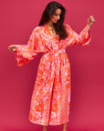 A cotton robe with pockets and an orange and hot pink tropical floral print. 