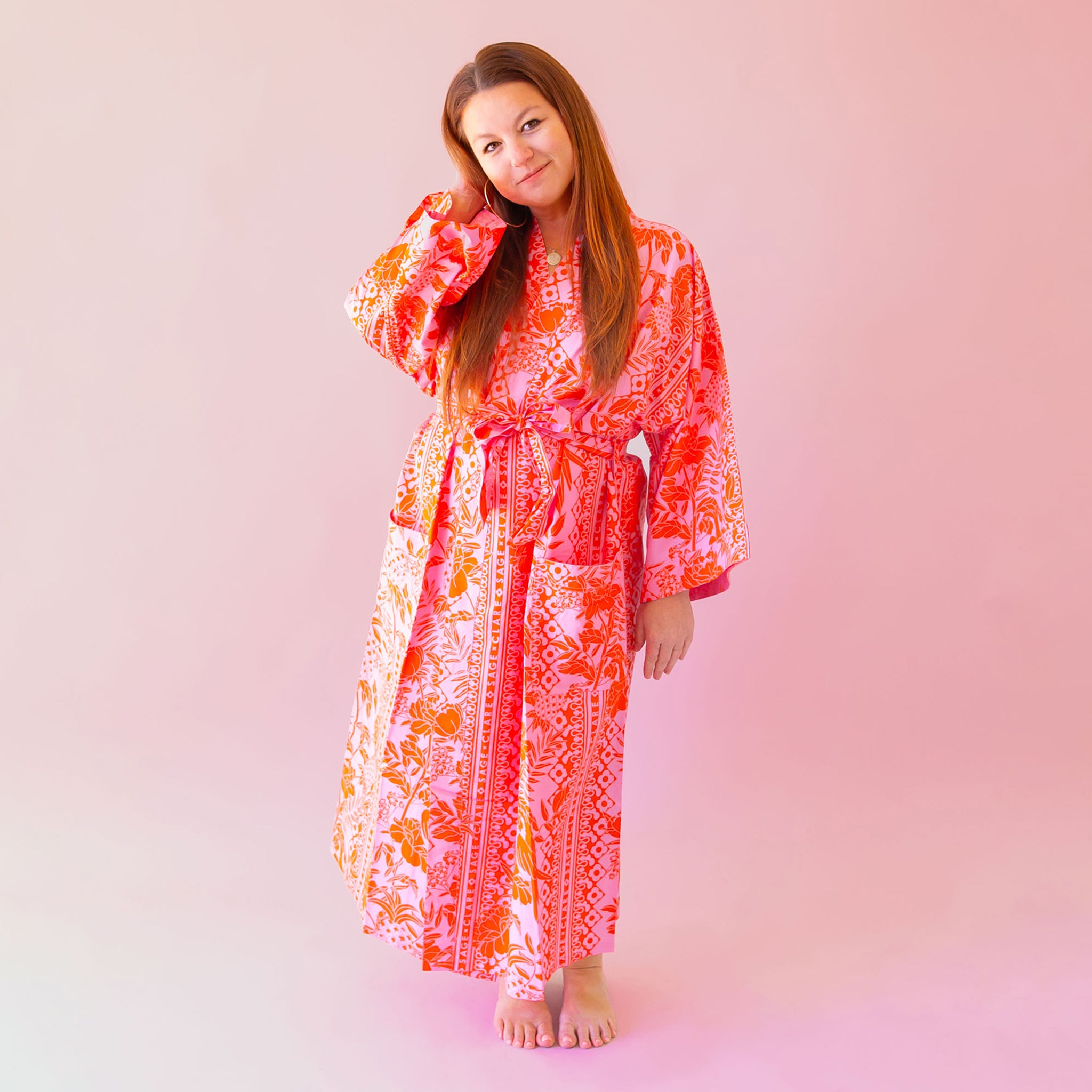 A cotton robe with pockets and an orange and hot pink tropical floral print.