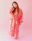 A cotton robe with pockets and an orange and hot pink tropical floral print.