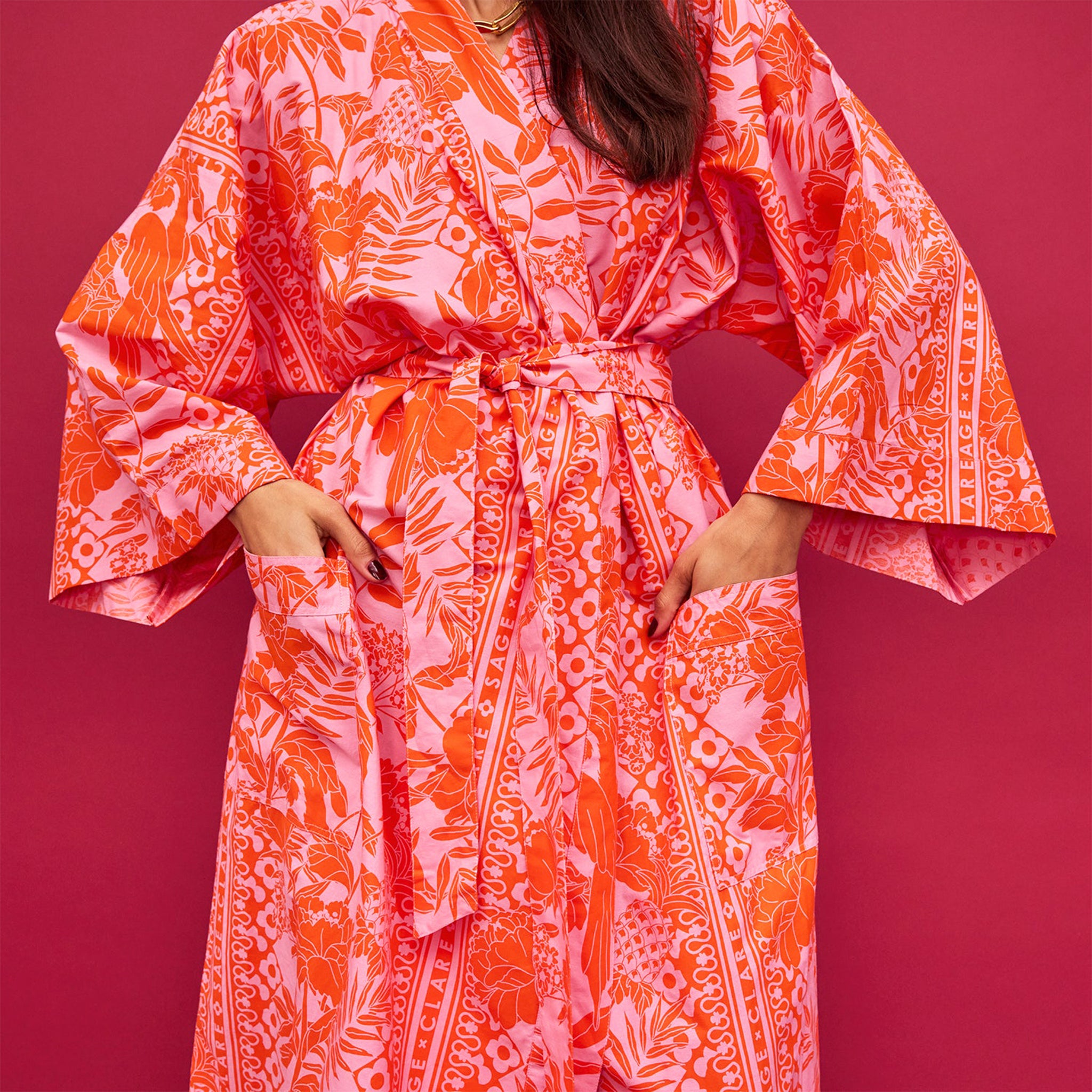 A cotton robe with pockets and an orange and hot pink tropical floral print.