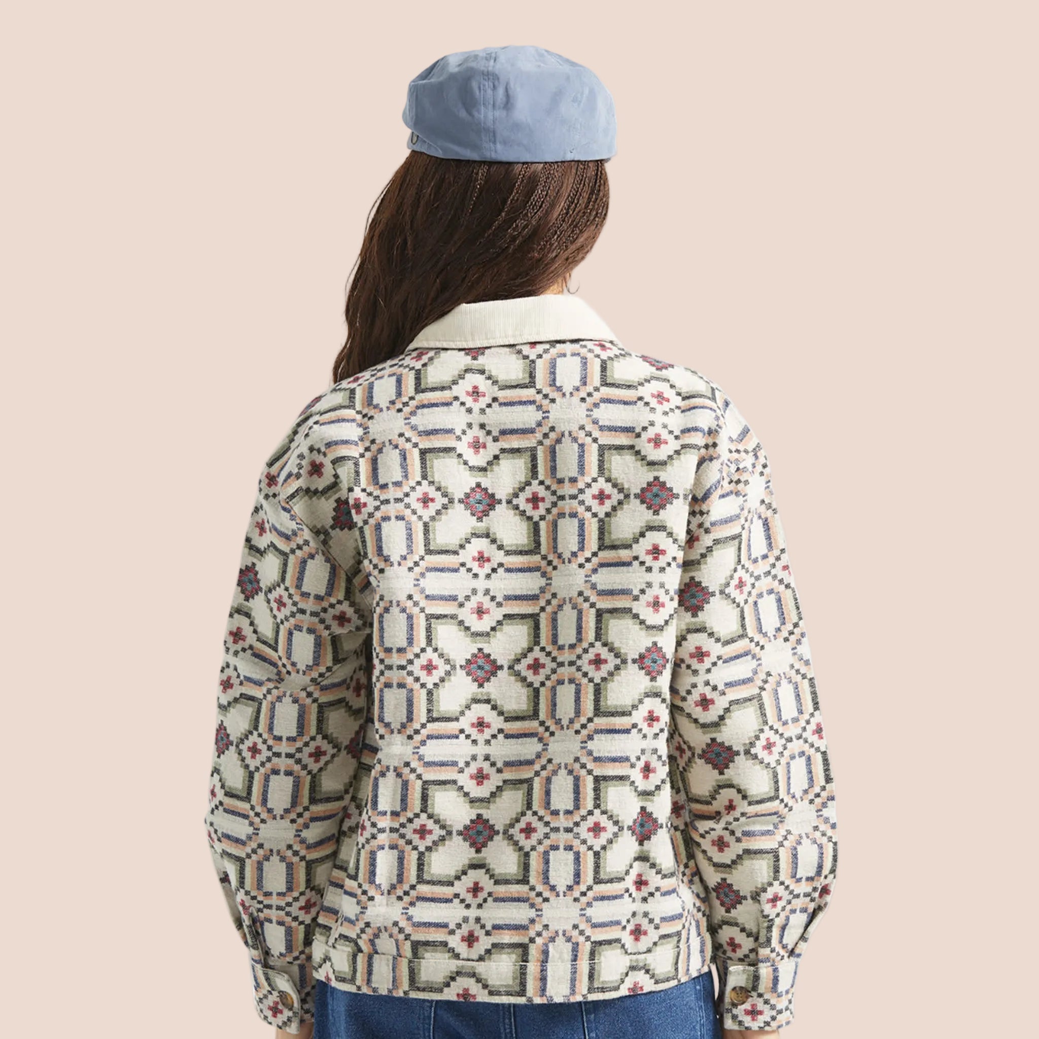 A button up jacket with a collar and a geometric print. 