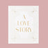 On a pink background is an ivory photo album cover with gold text that reads, "A Love Story". 