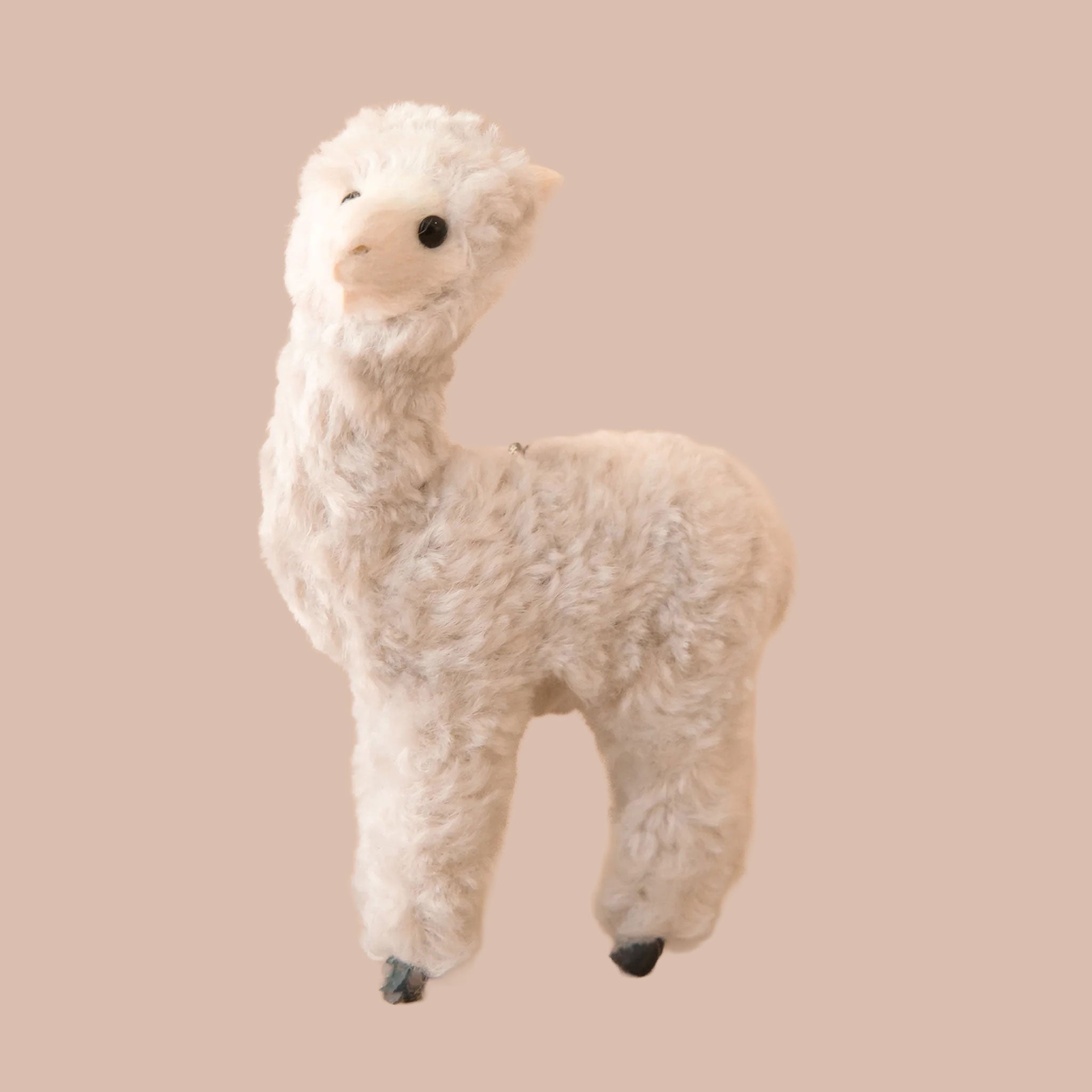 A cream colored alpaca ornament. 