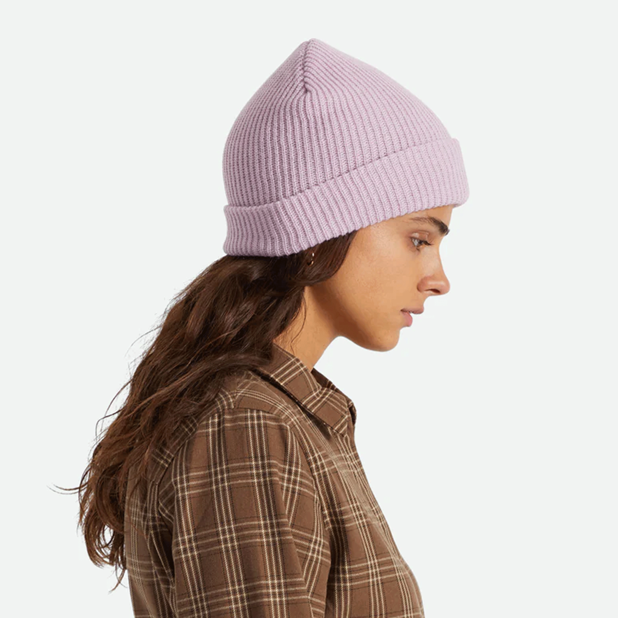 On a white background is a light purple knit beanie worn on a model. 
