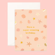 On a pink background is a apricot colored card with a shell pattern and gold foiled text that reads, "Have a super amazing birthday.". 