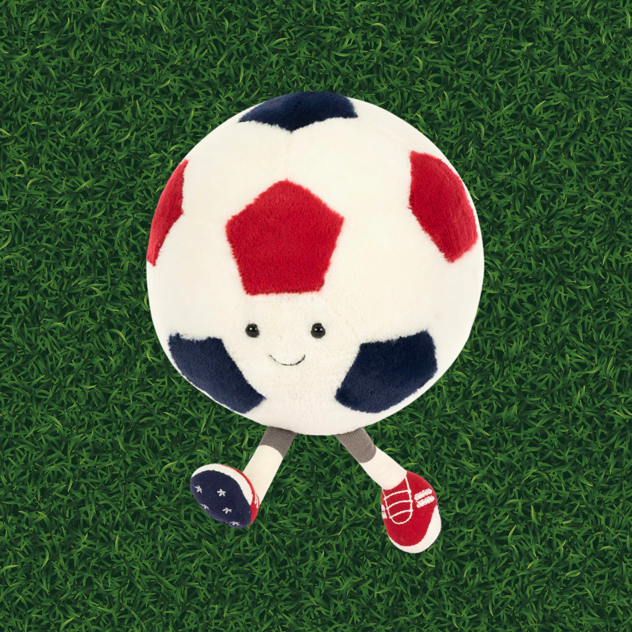 Plush soccer ball toy with a smiling face on a green background