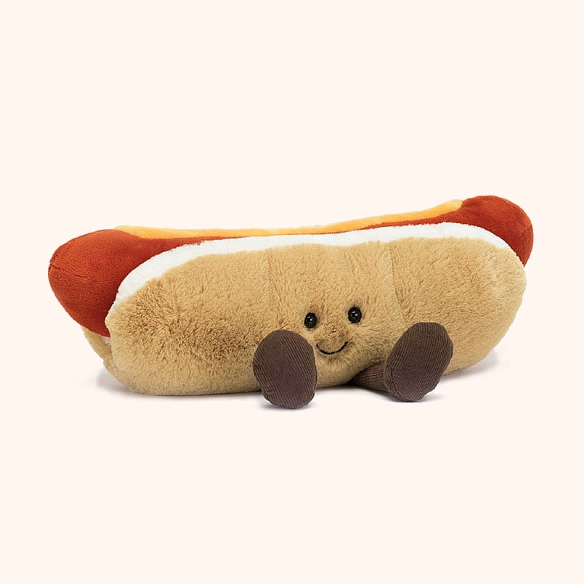 On a neutral background is an amusable hot dog stuffed animal. 