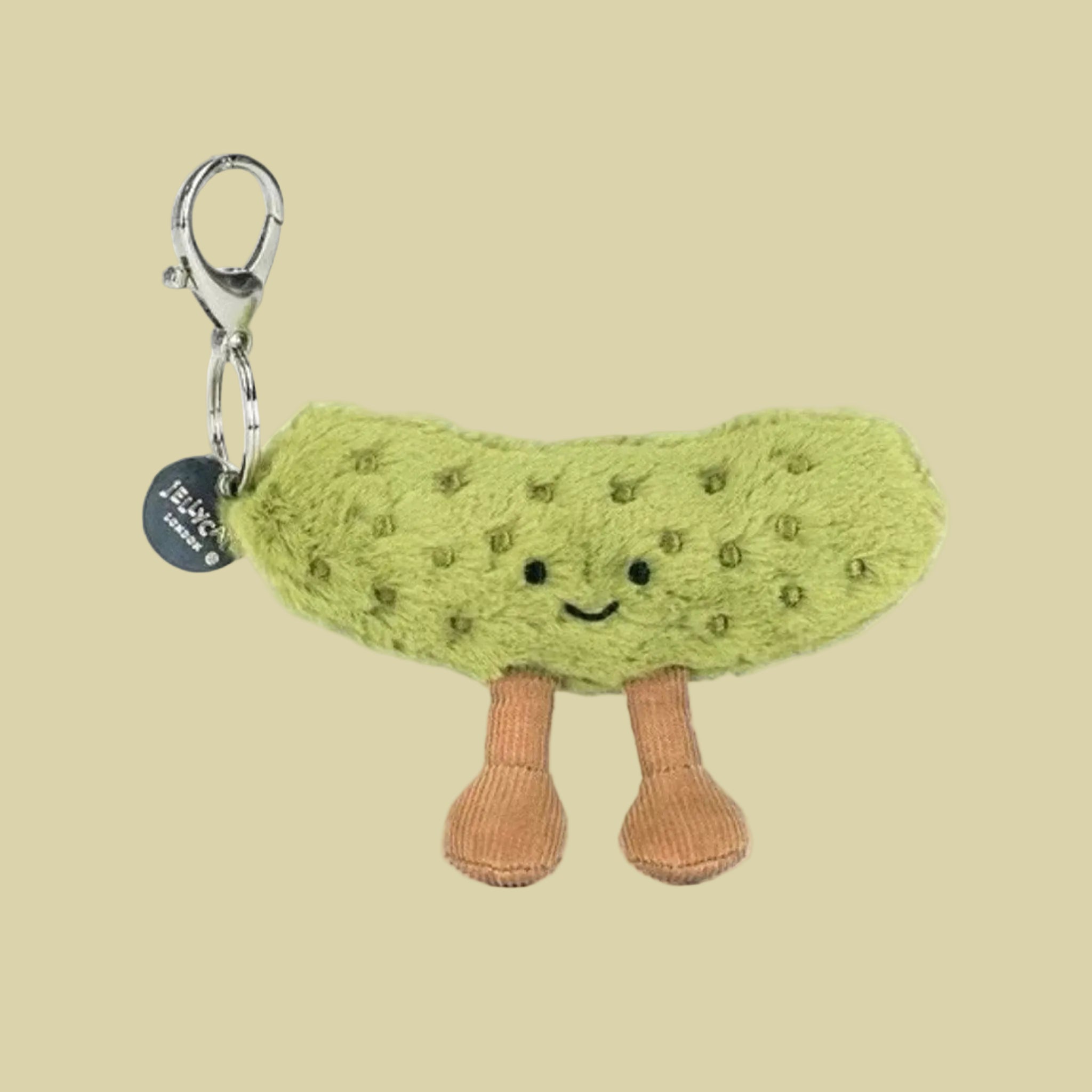 A pickle shaped stuffed toy bag charm keychain. 