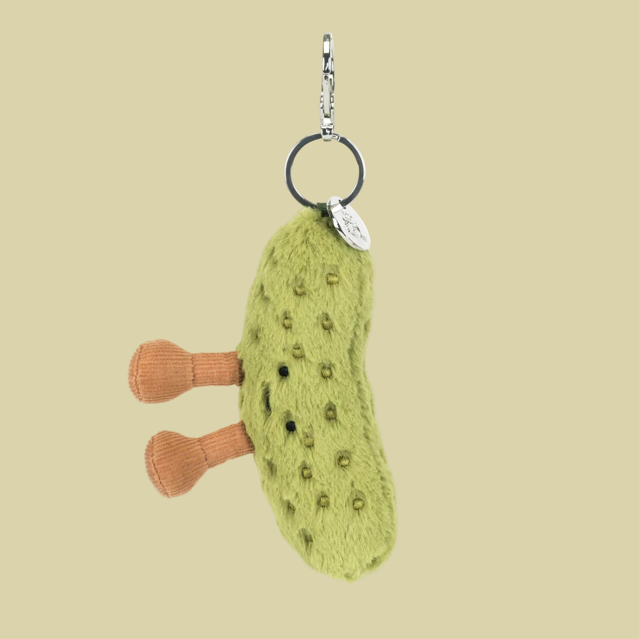 A pickle shaped stuffed toy bag charm keychain. 