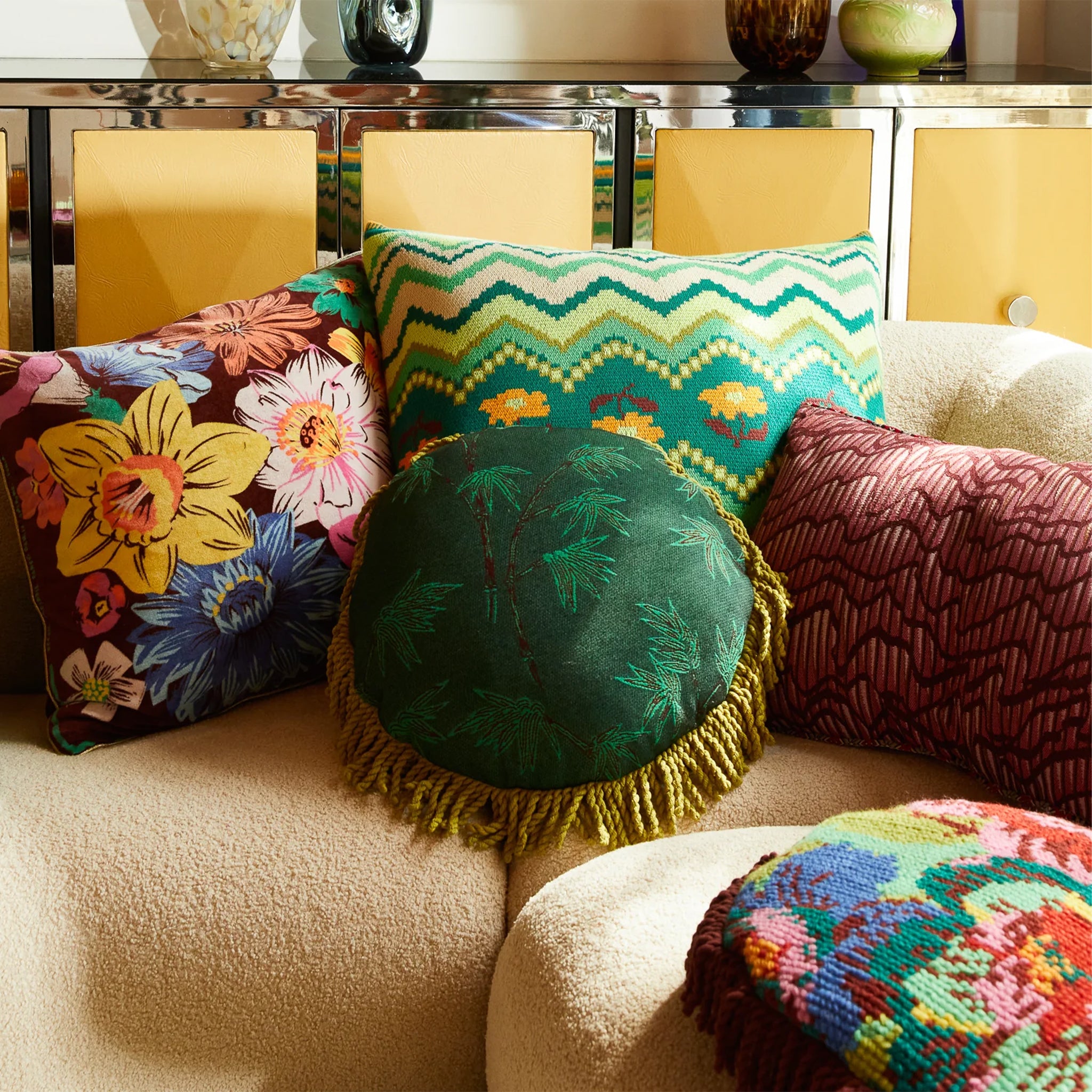 Colorful pillows on a sofa with a decorative table in the background