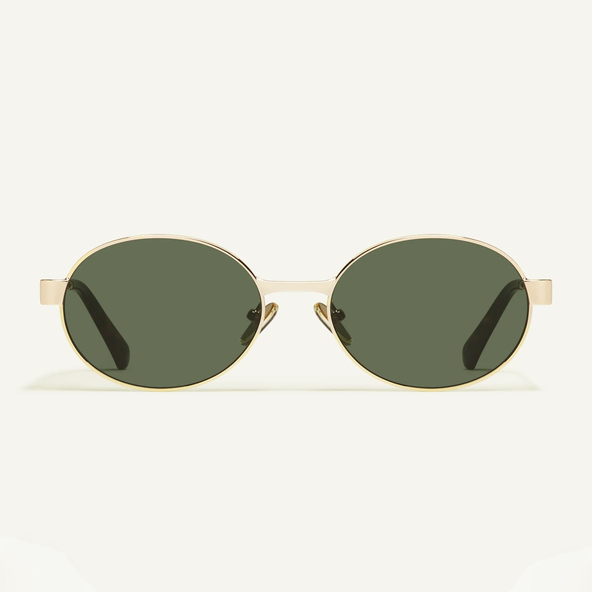 A gold metal pair of sunglasses with greenish hued lenses.