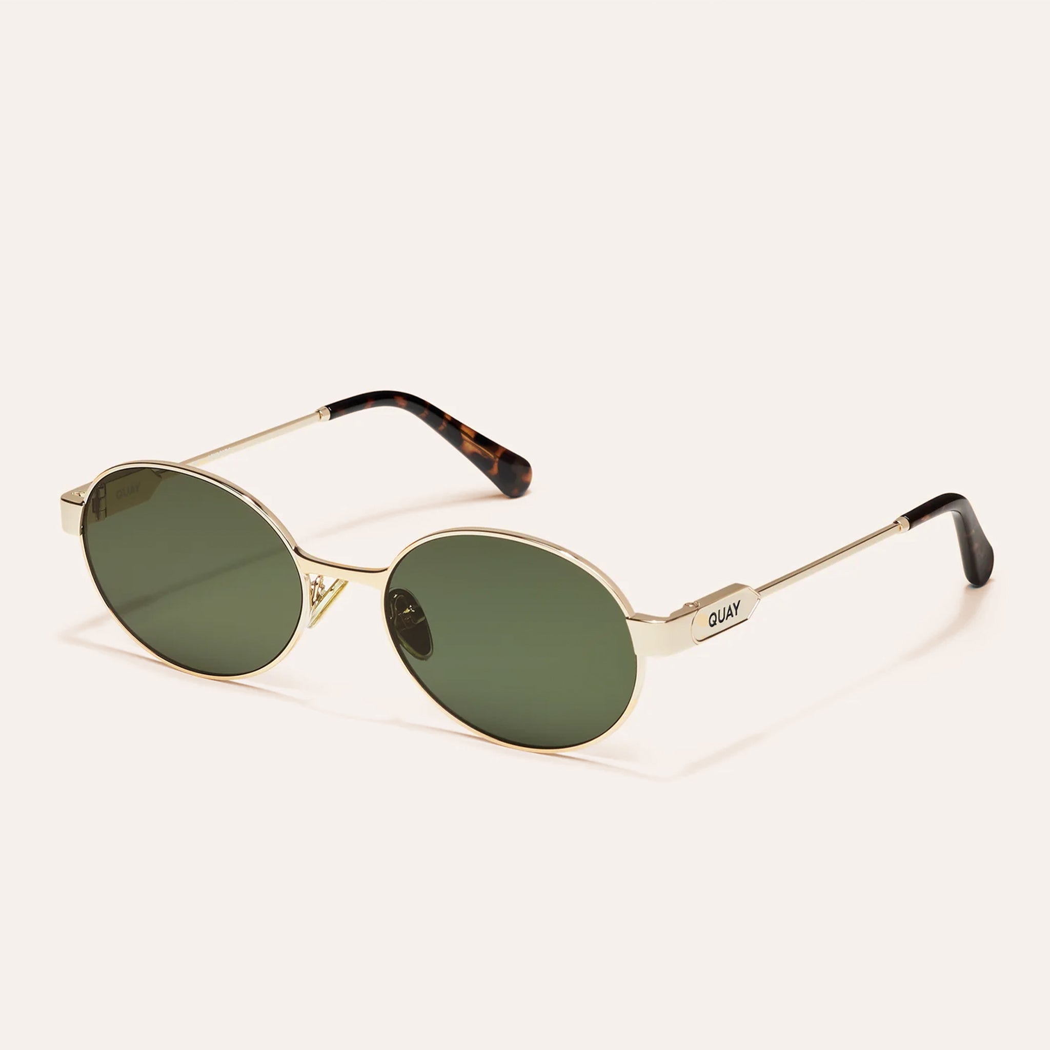 A gold metal pair of sunglasses with greenish hued lenses.