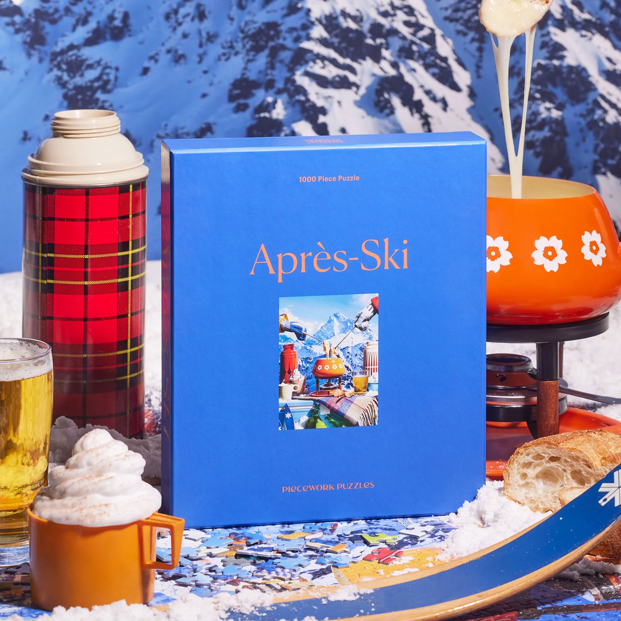 A look at the finished puzzle featuring an image of a mountain range and a vintage fondue pot along with other warm beverages.