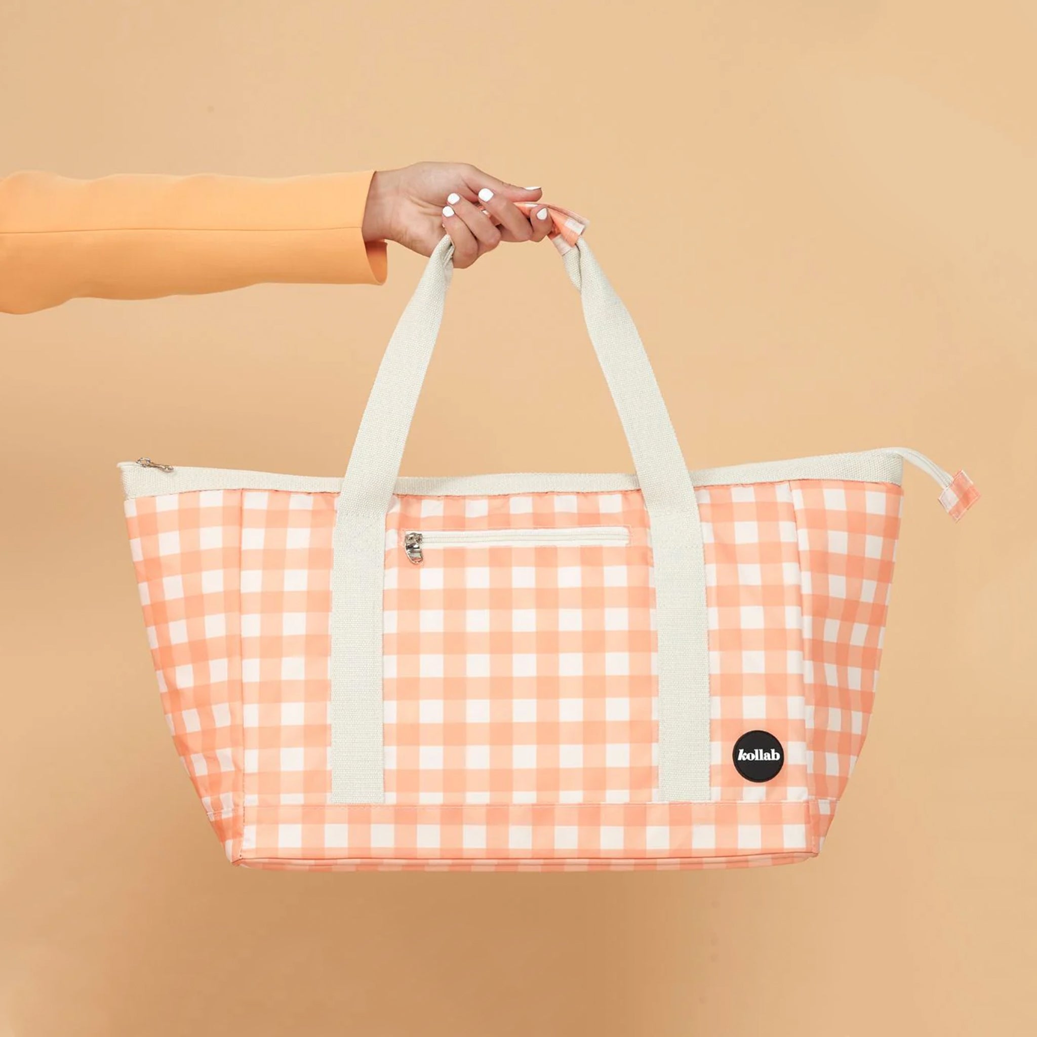 An apricot and ivory checkered print tote bag with two straps. 