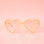 On a neutral background is a pair of apricot heart shaped glasses.