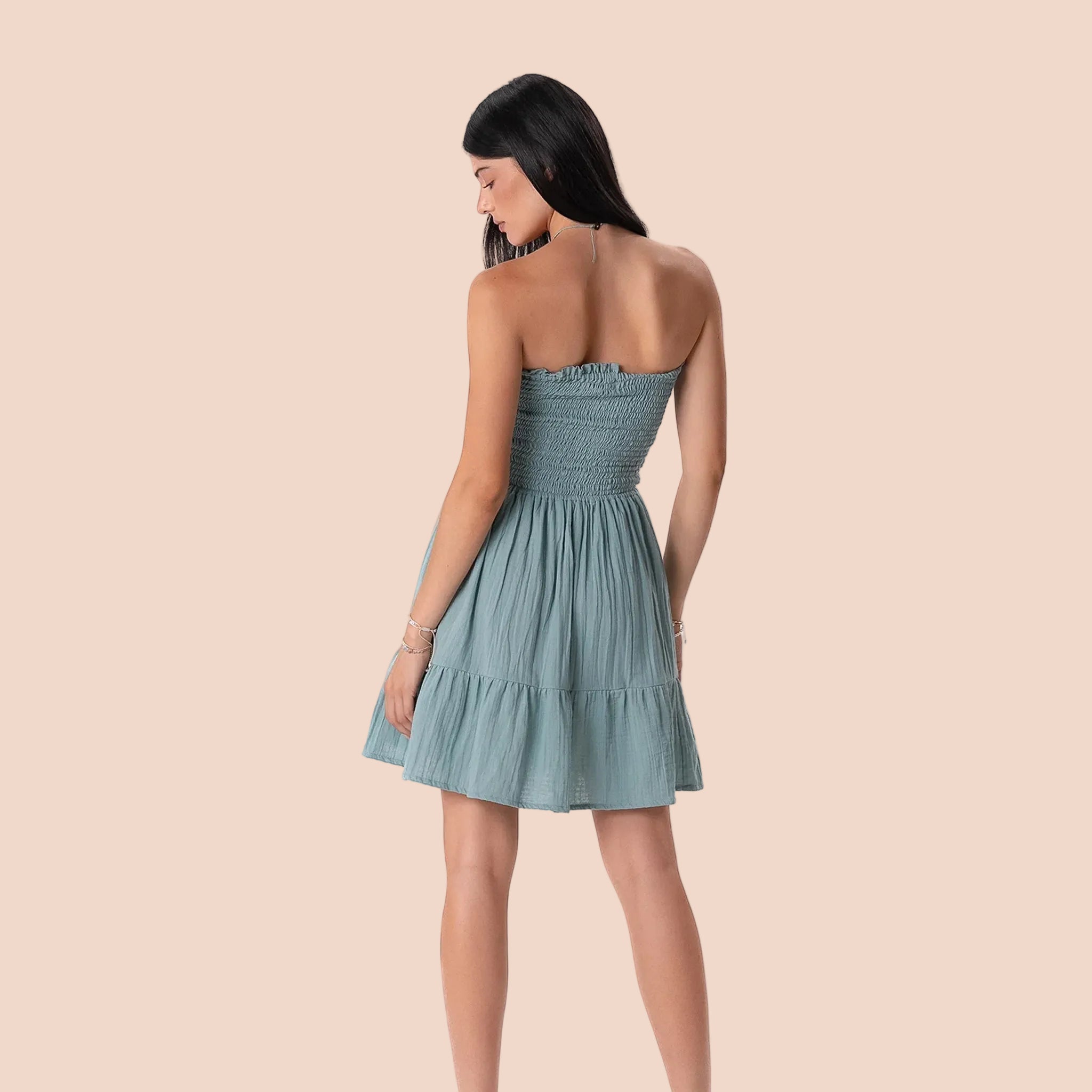 Woman wearing a strapless aqua dress on a white background