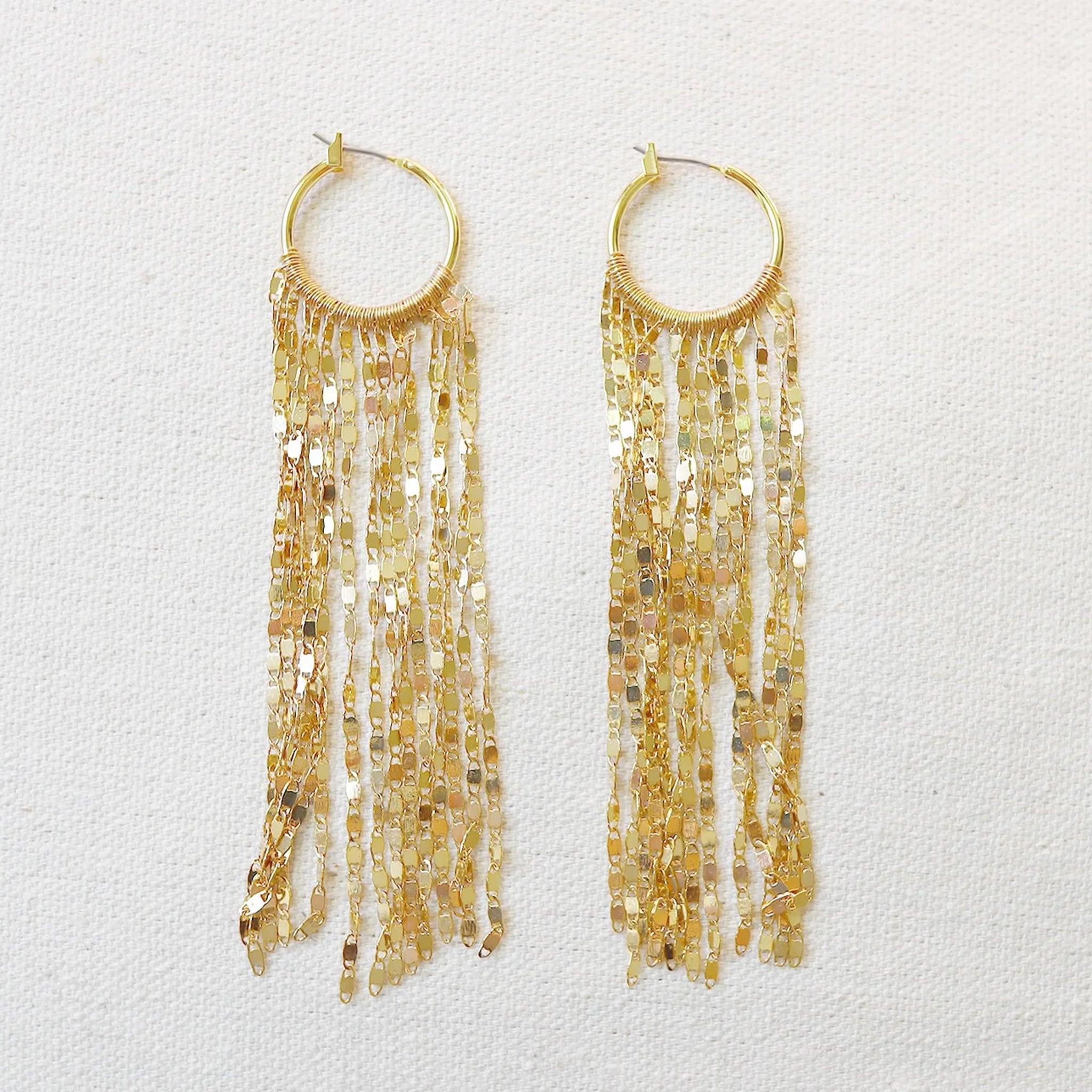 A pair of gold hoop earrings with dangle chains from the bottom.