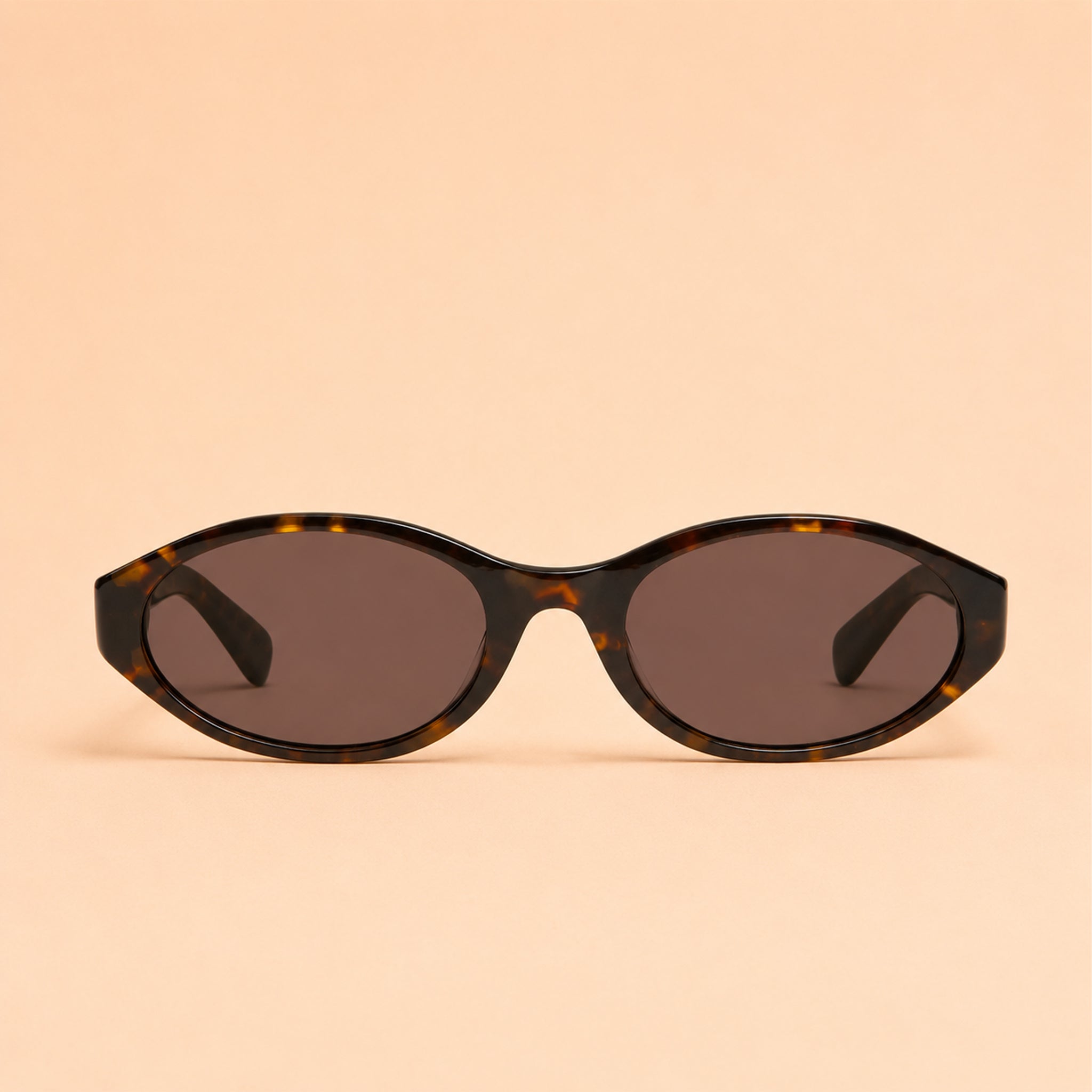 Sunglasses with tortoiseshell frame and dark lenses on a beige background