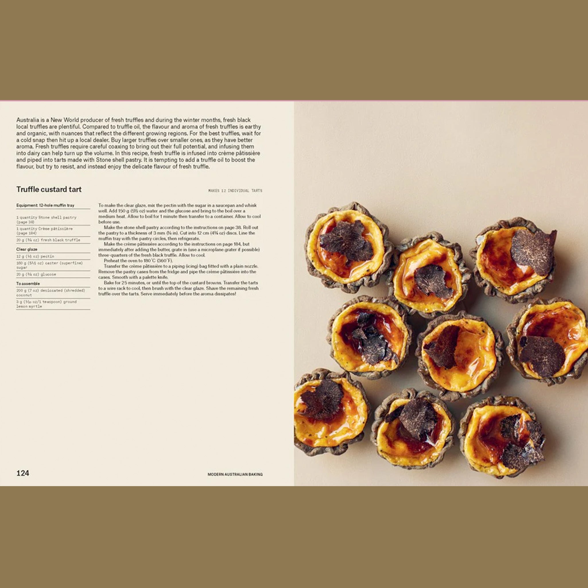 Open cookbook spread featuring a truffle custard tart recipe, with instructions on the left and a styled overhead photo of mini custard tarts with caramelized tops and shaved truffle on the right.
