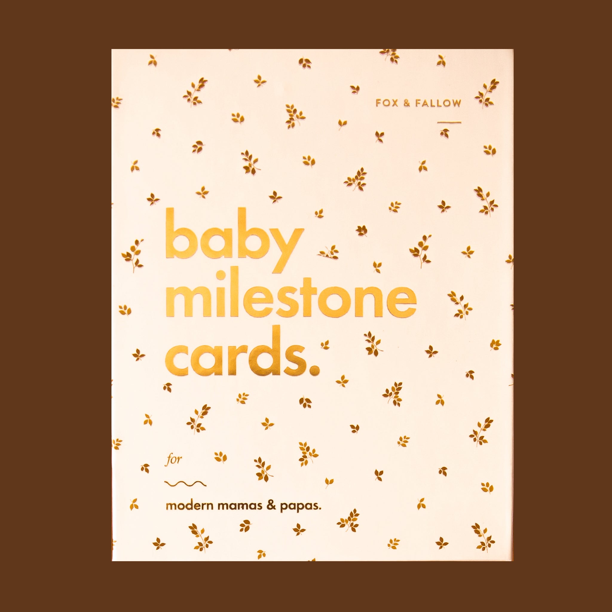 On a brown background is a neutral box with text that reads, "baby milestone cards.". 