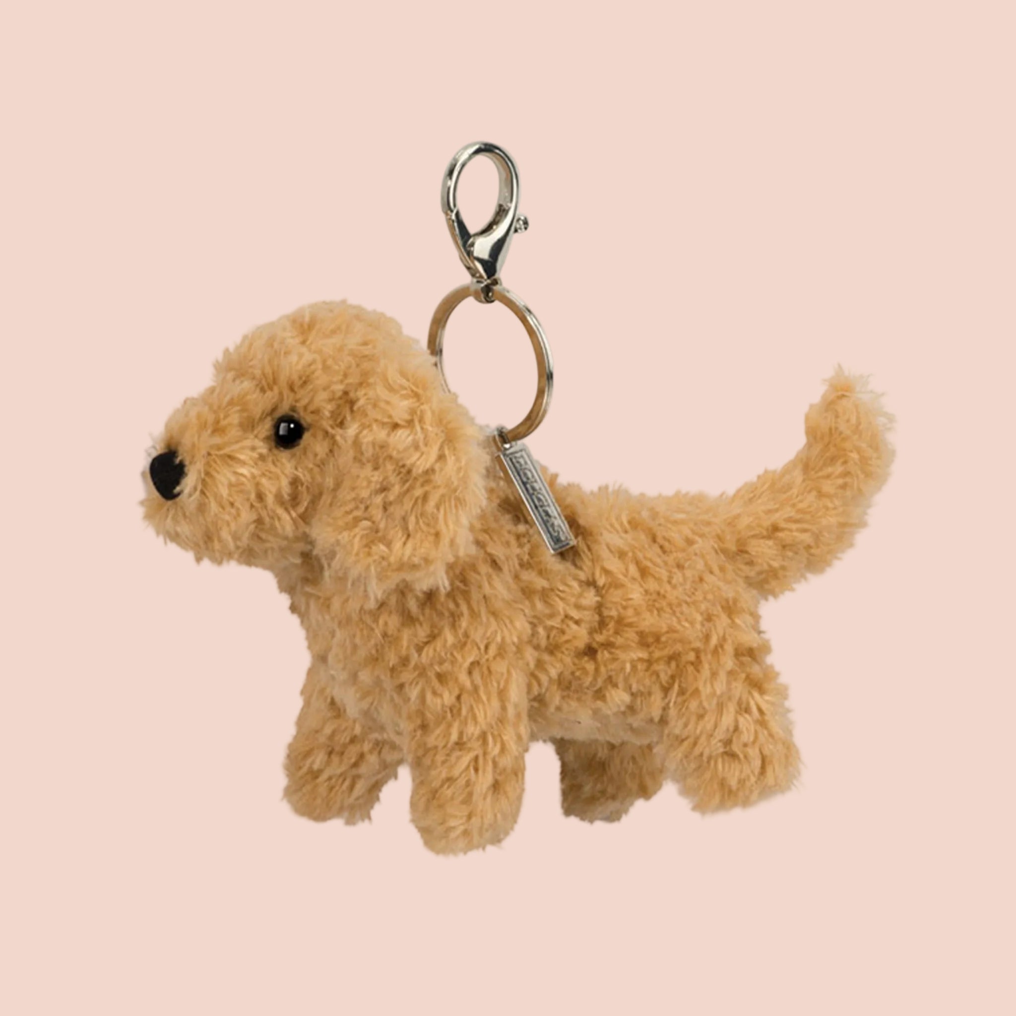 A tan doodle shaped toy keychain bag charm. 