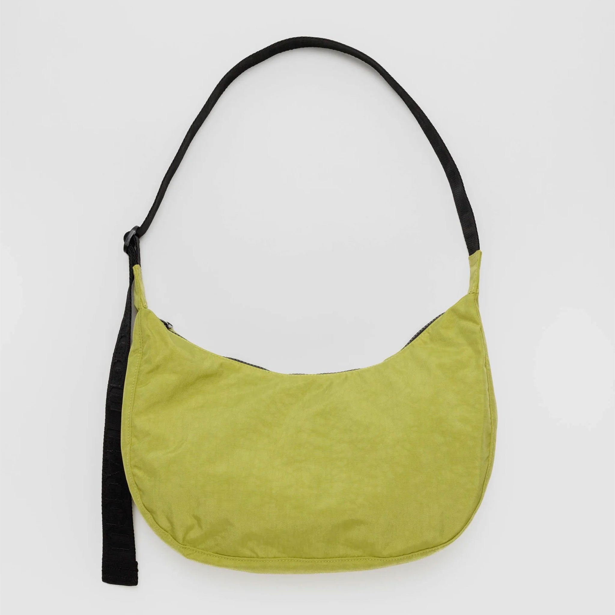 A crescent shaped bag in a lime green color with a black strap. 