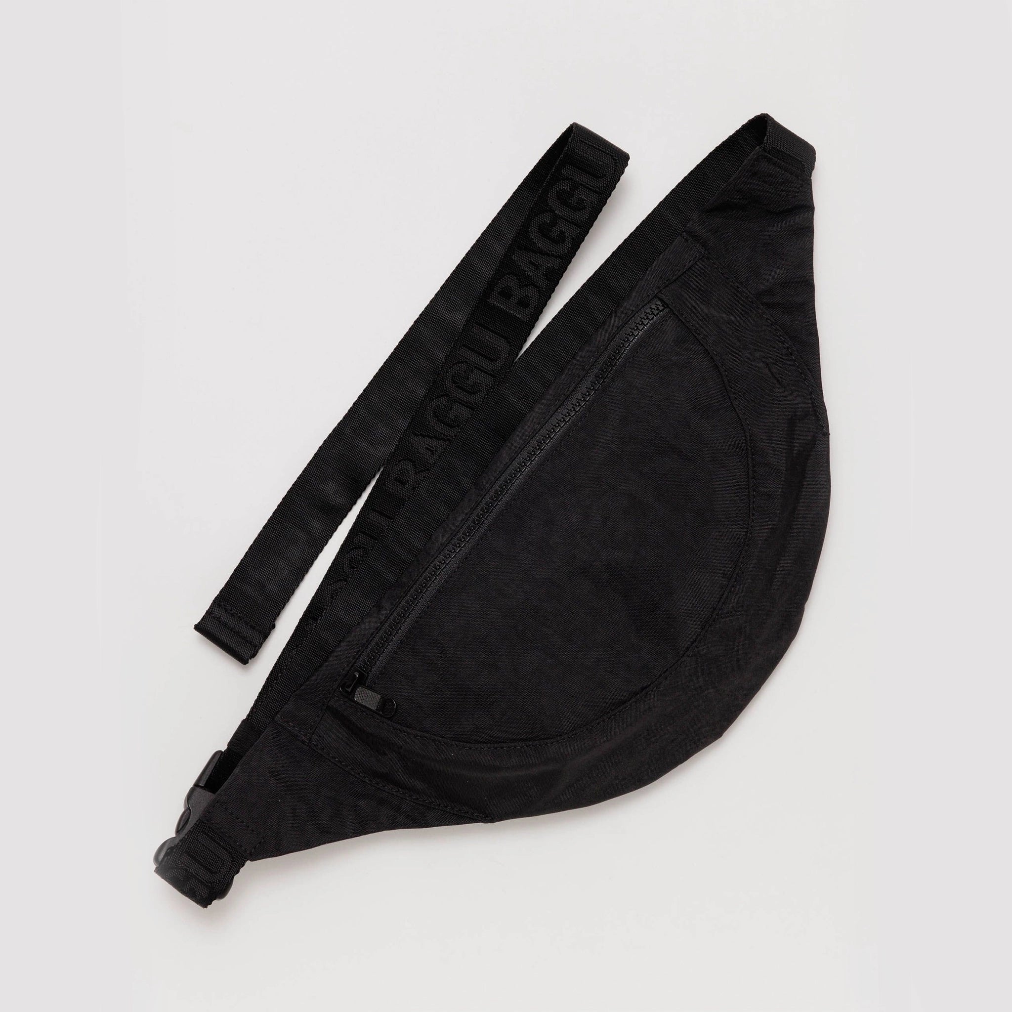 On a white background is a black fanny pack with a front pocket with a black adjustable strap. 