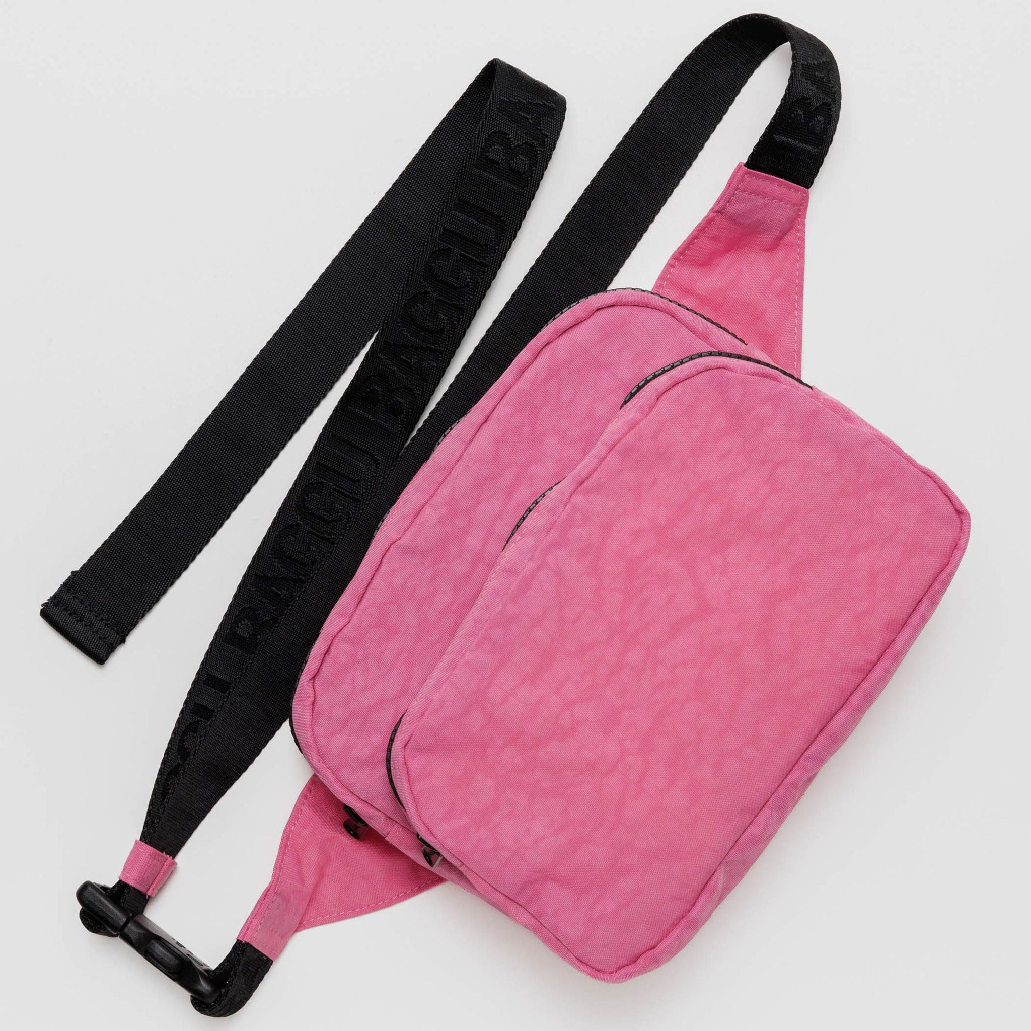 a bright pink fanny pack with black strap