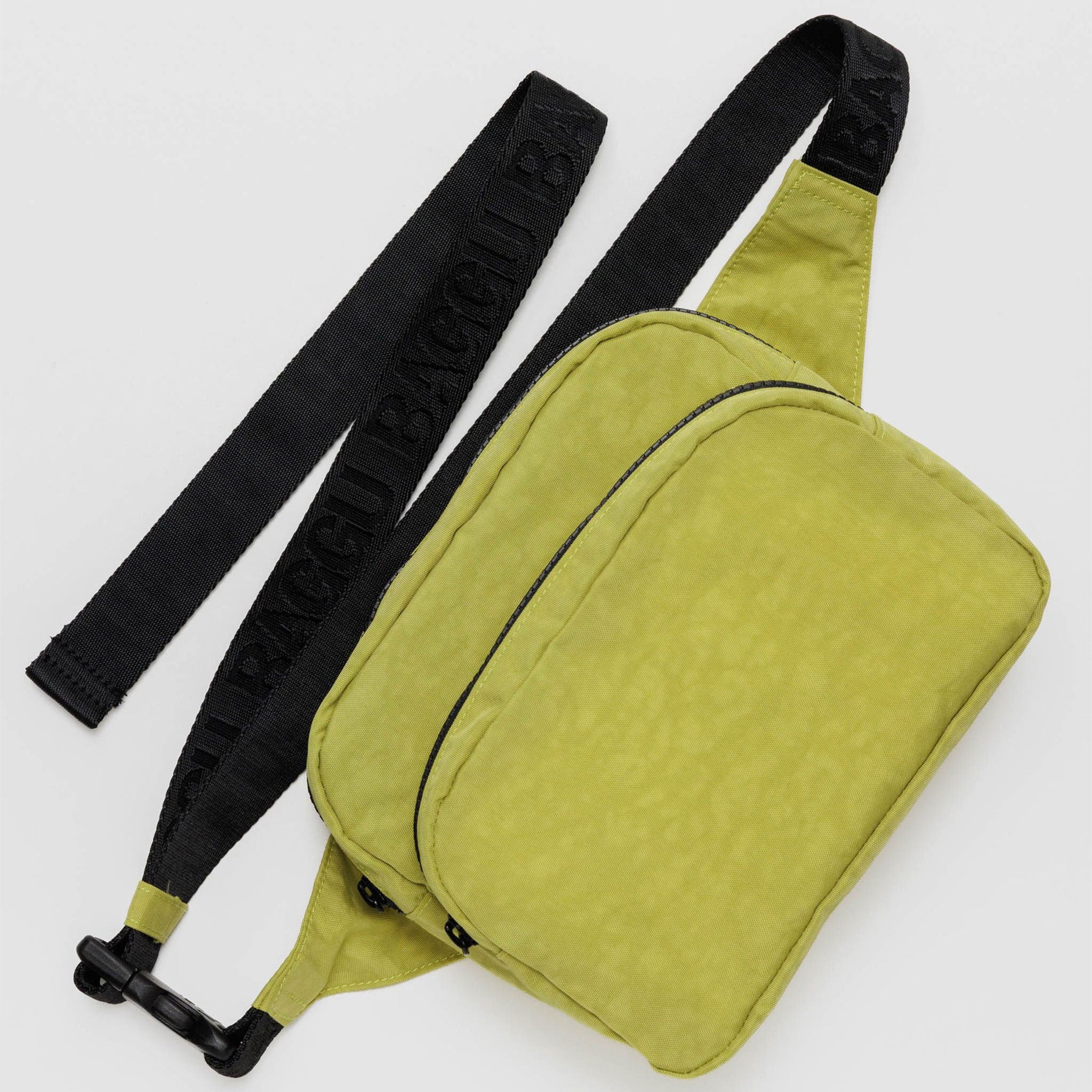 On a white background is a lime green nylon fanny pack with black accents and a black adjustable strap. 