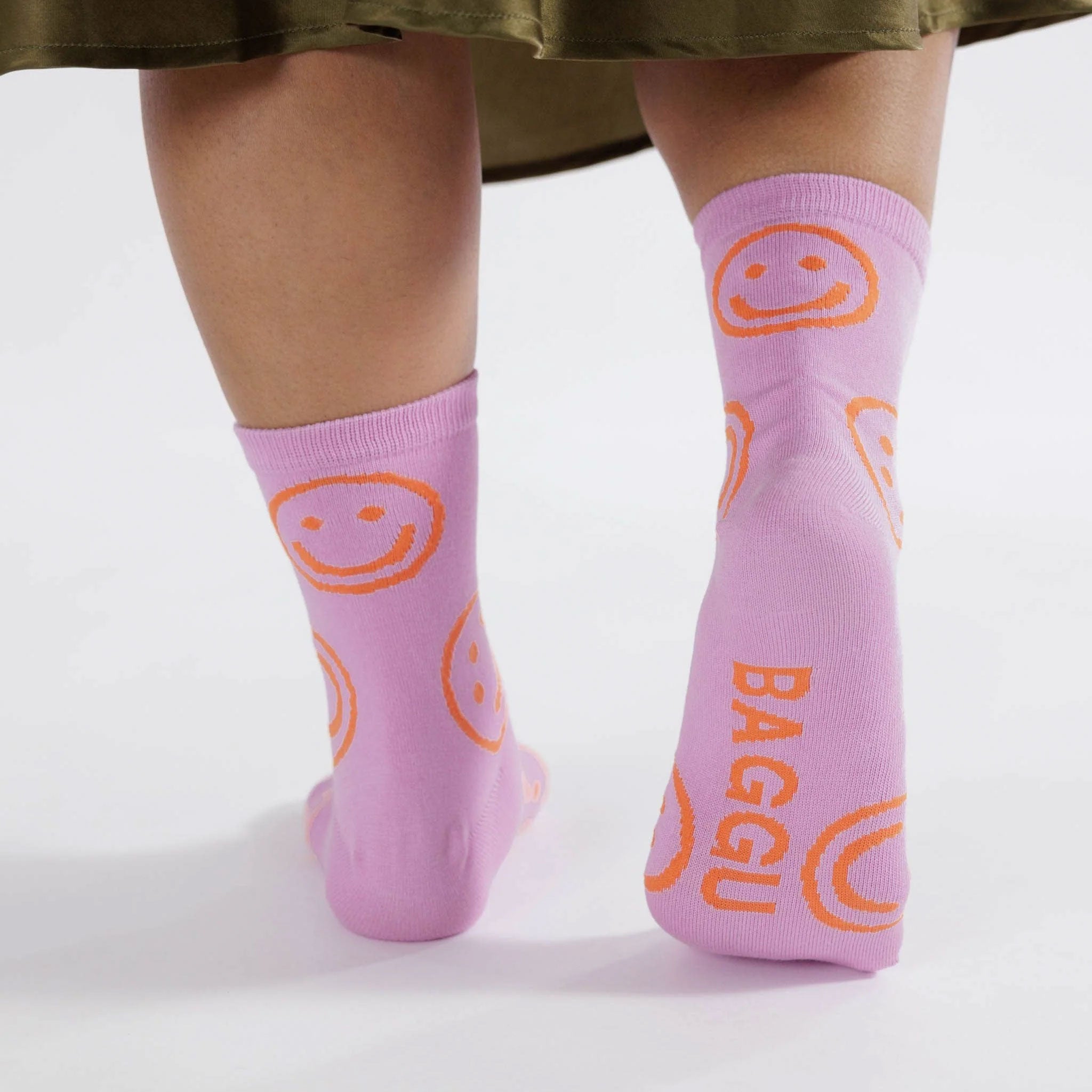 pink socks with orange smiley faces worn on a woman's feet