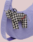 A black and white checkered horse shaped bag charm. 