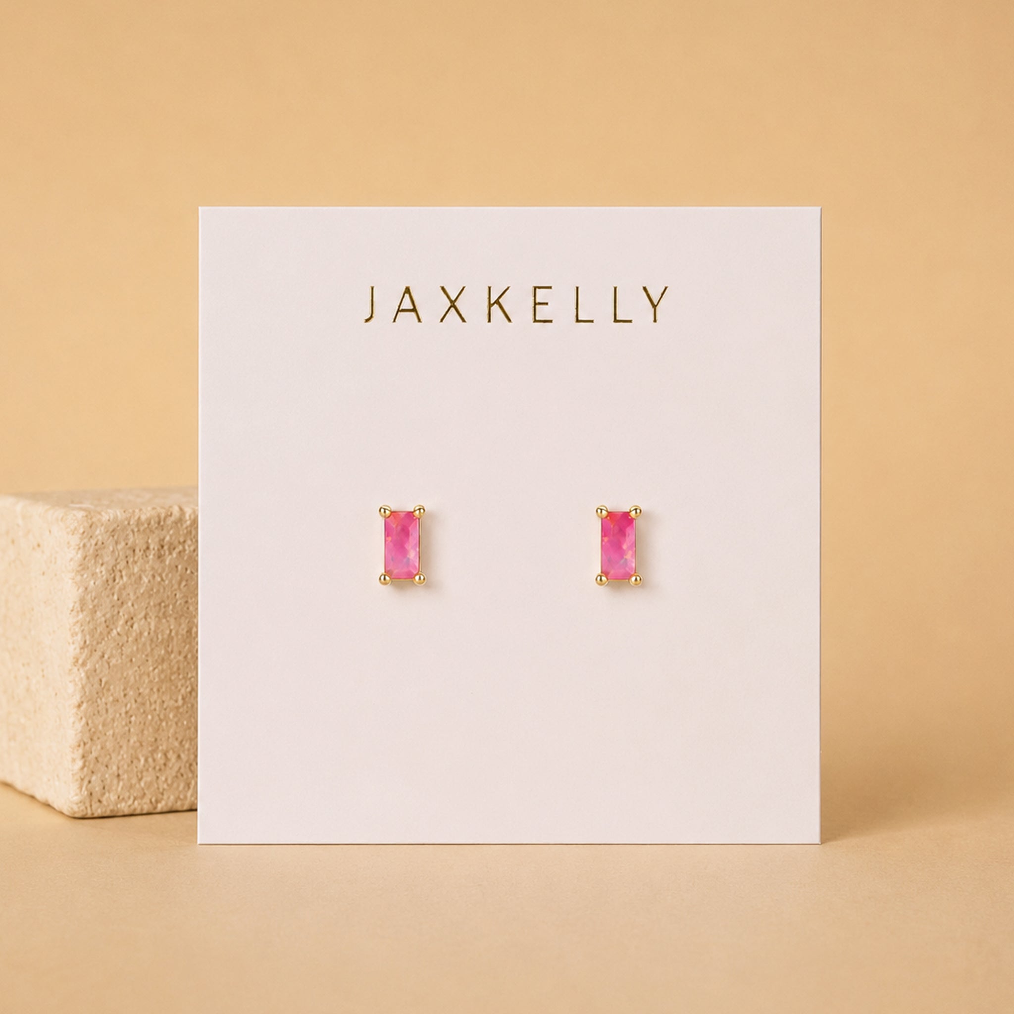 Pink gemstone earrings on a Jaxkelly branded card with a beige background