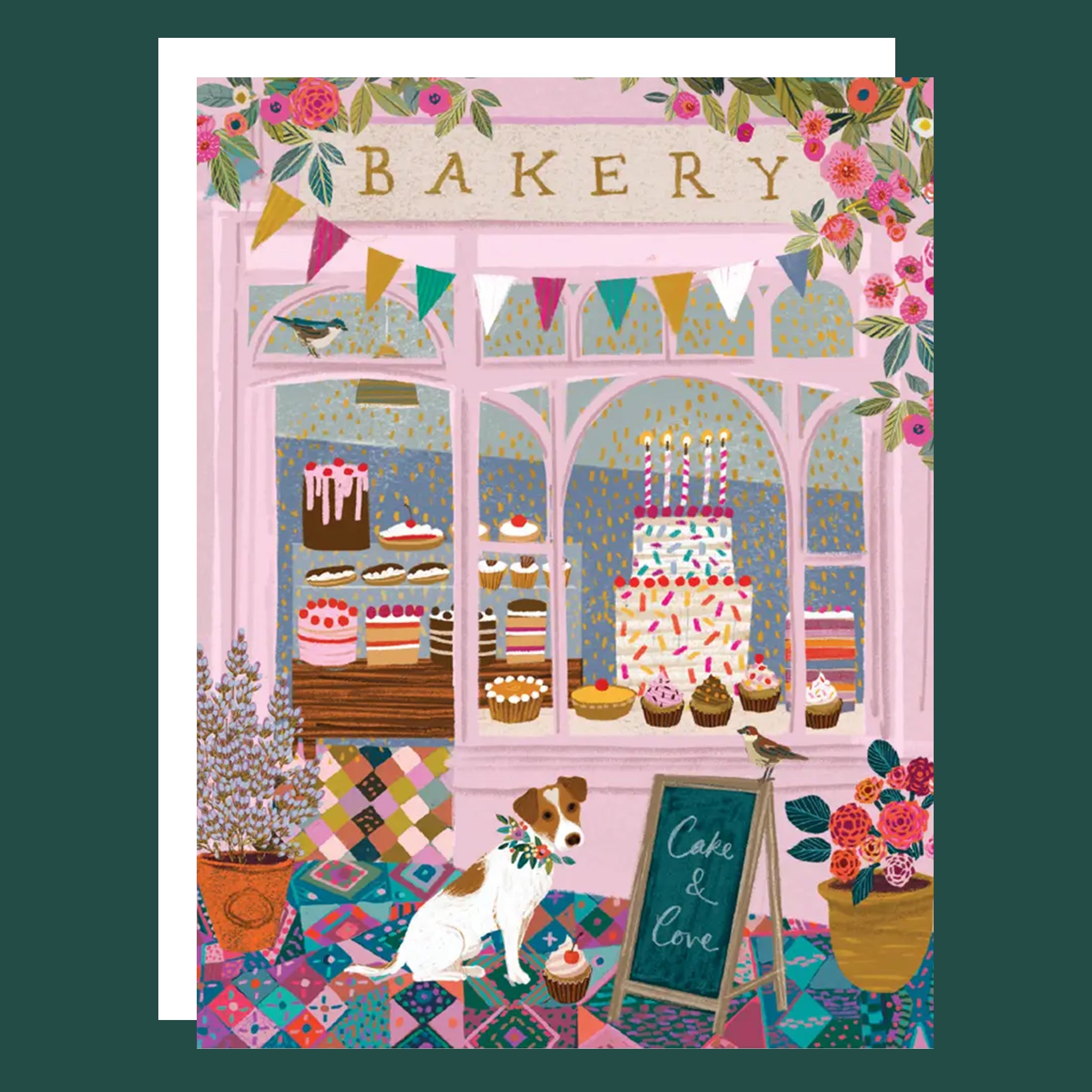 Greeting card of the front of a bakery shop. The shop showcases birthday cakes in the window, there is a dogs and a sign that reads "Cake & Love". 