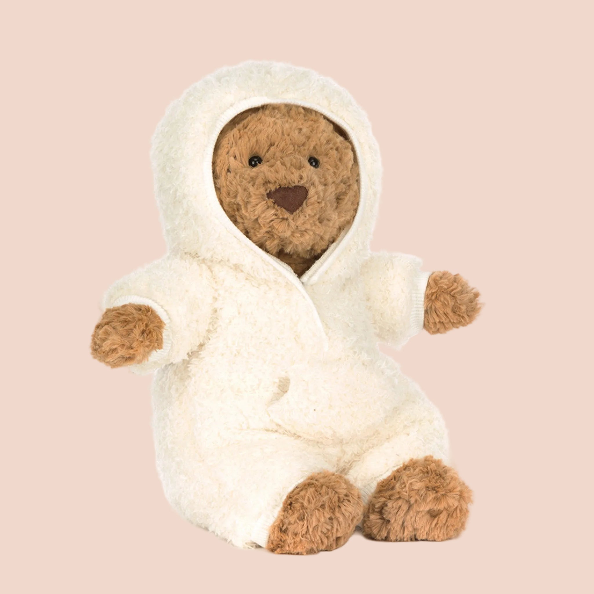 A bear shaped stuffed animal toy with a single white fluffy outfit on. 