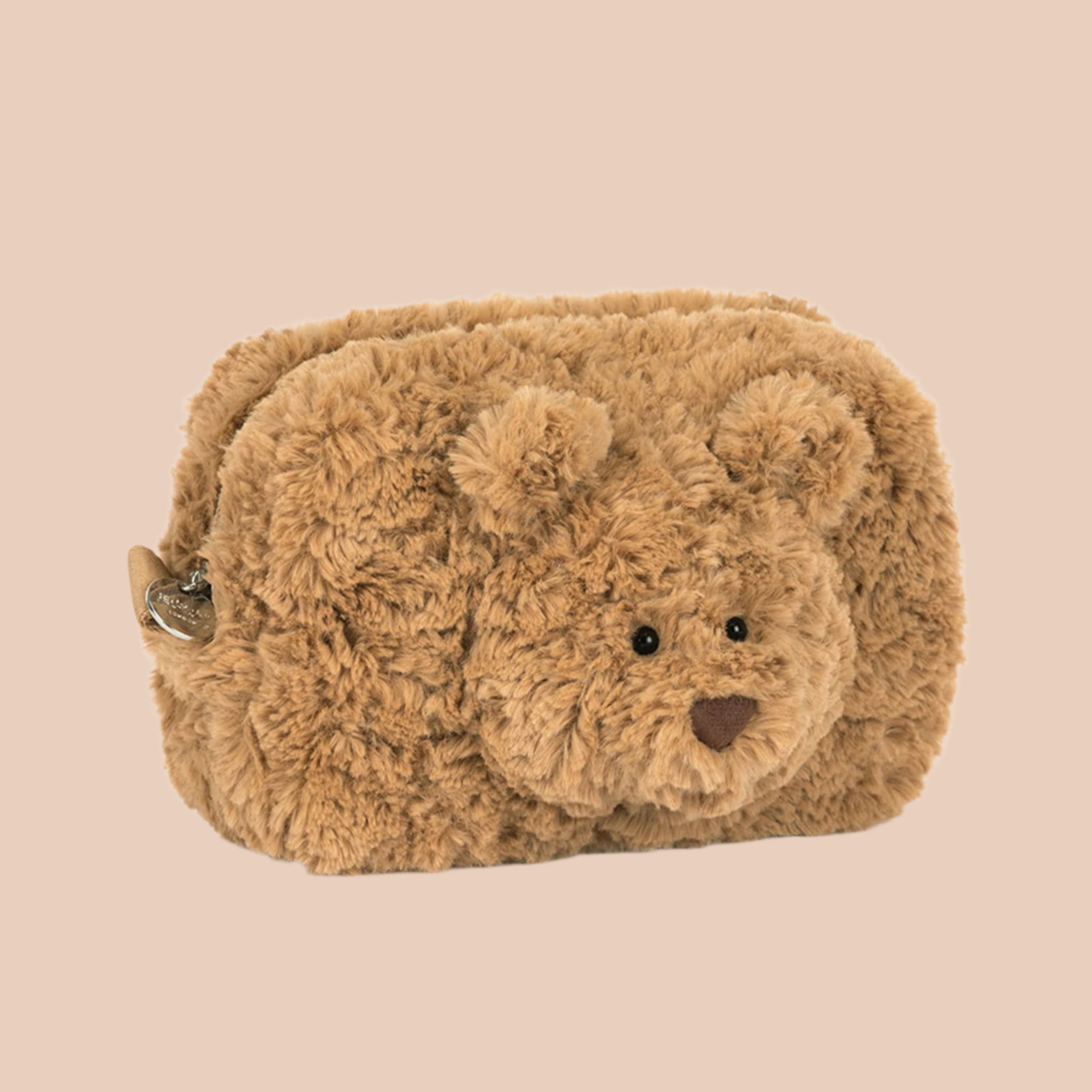 A tan furry pouch with a bear face in the center. 