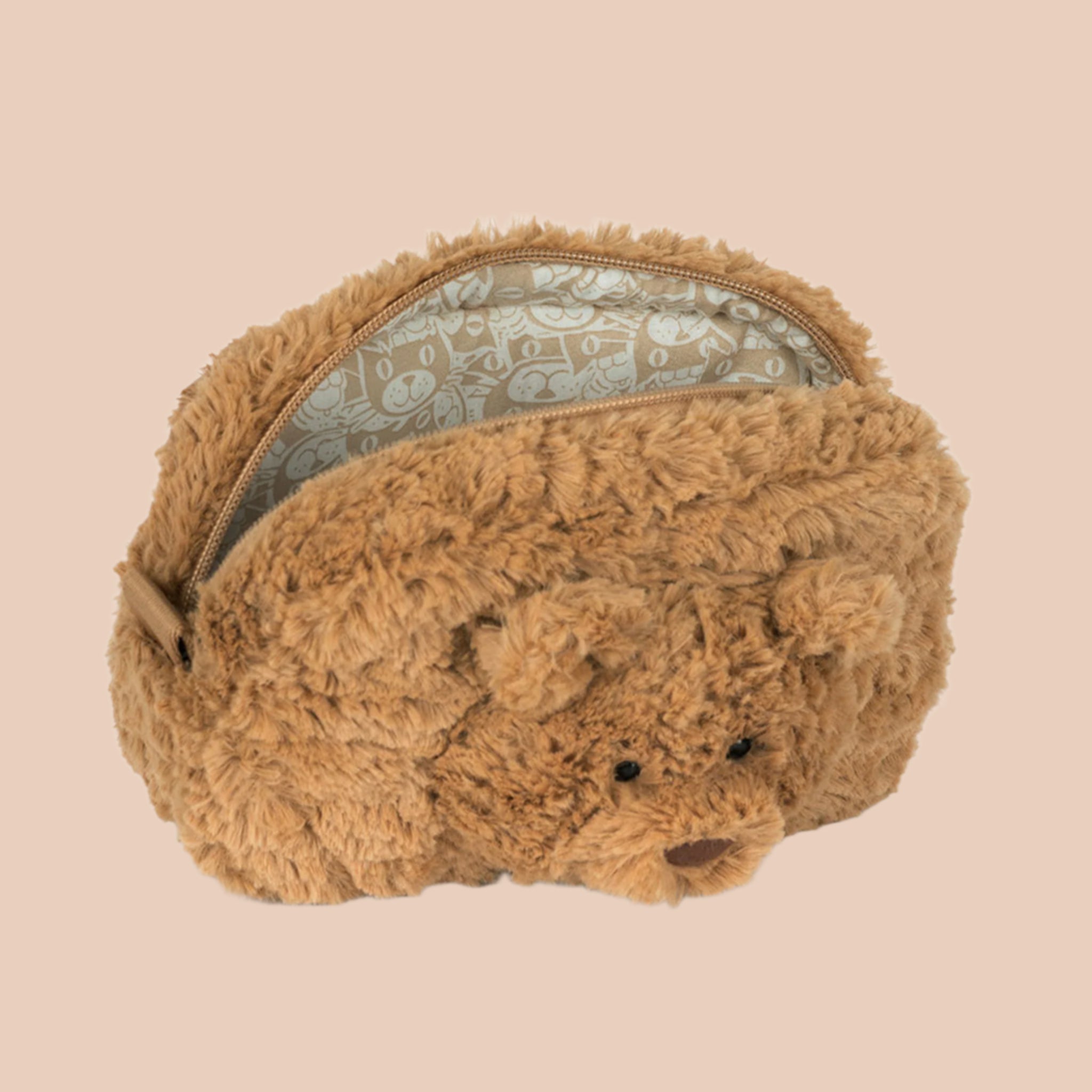 A tan furry pouch with a bear face in the center. 
