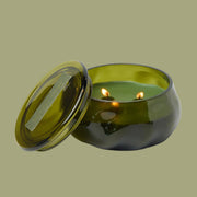 A green glass jarred candle with a lid. 