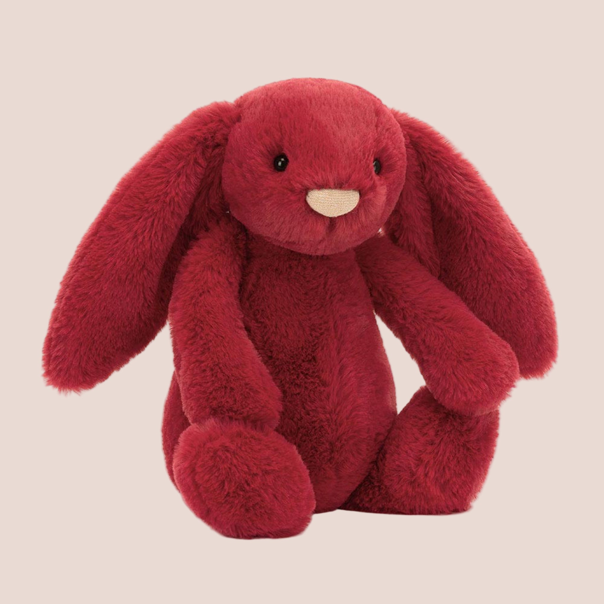 A red bunny stuffed animal toy. 